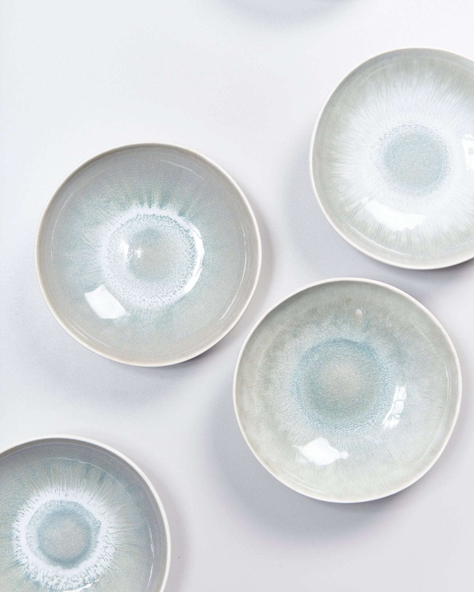 Fünf runde, blaue Keramikteller mit Mustern auf einem weißen Hintergrund.