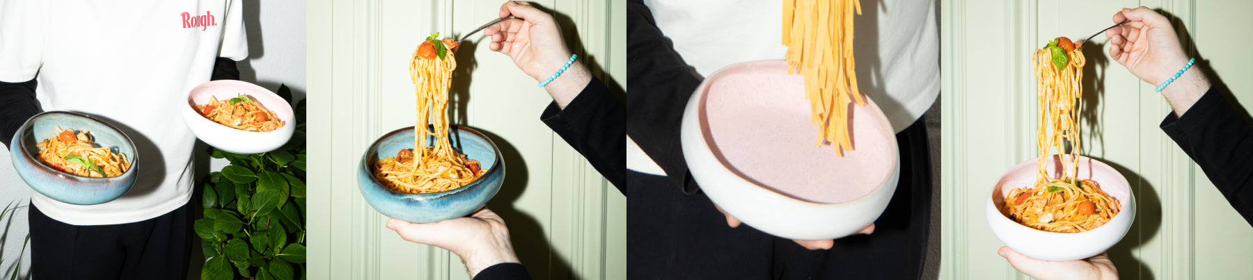 Person hält zwei Schalen mit Spaghetti in verschiedenen Winkeln; eine blaue und eine rosa Schale, dekoriert mit Tomaten.