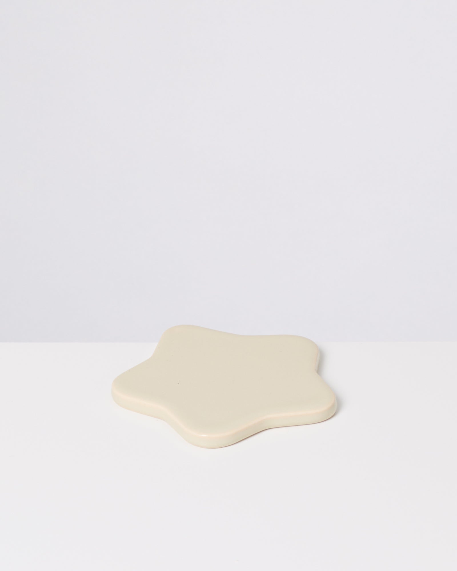 Beige sternförmiges Objekt auf weißem Hintergrund.