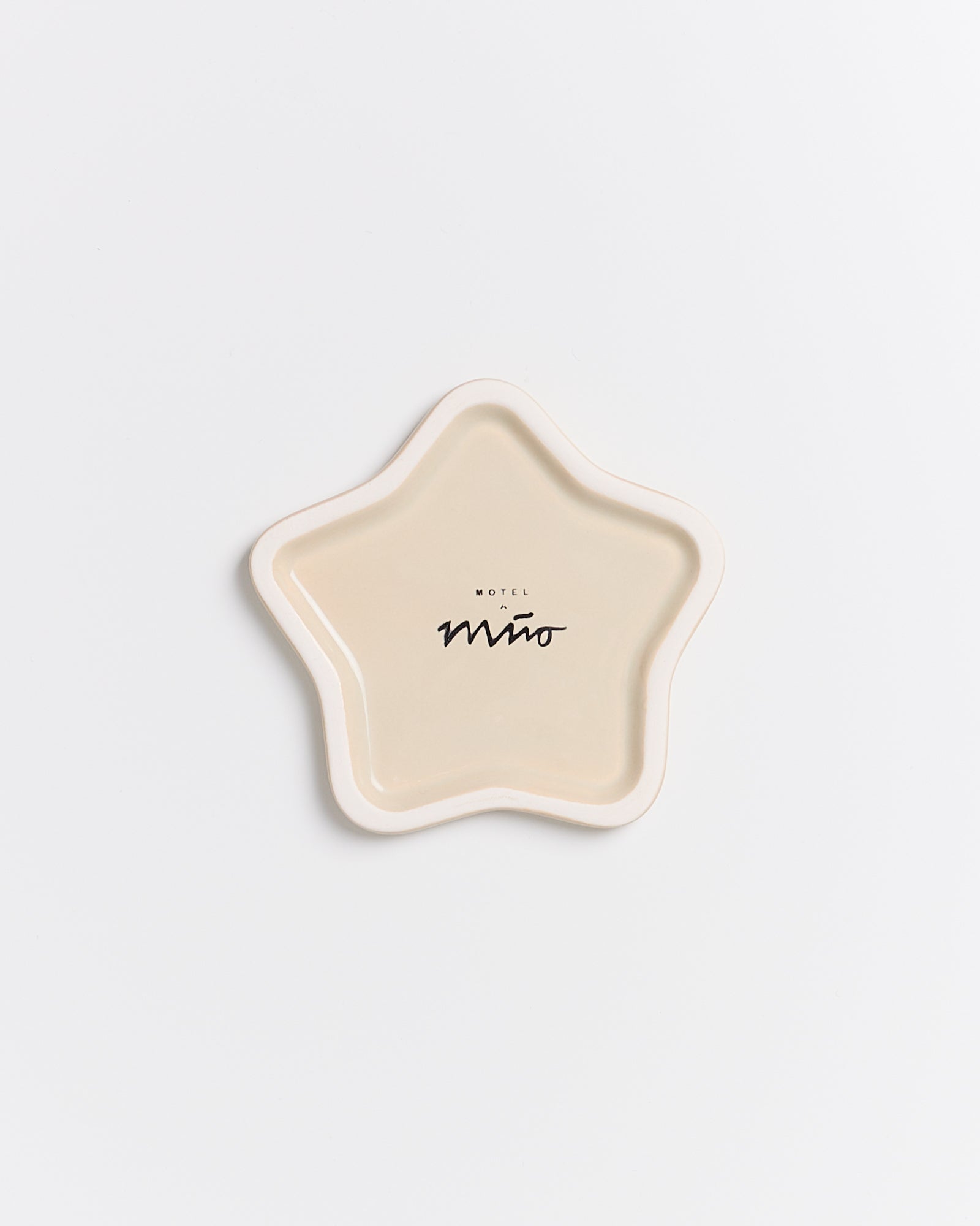 Sternförmige, beigefarbene Schale mit der Aufschrift "Motel Mino" auf weißem Hintergrund.
