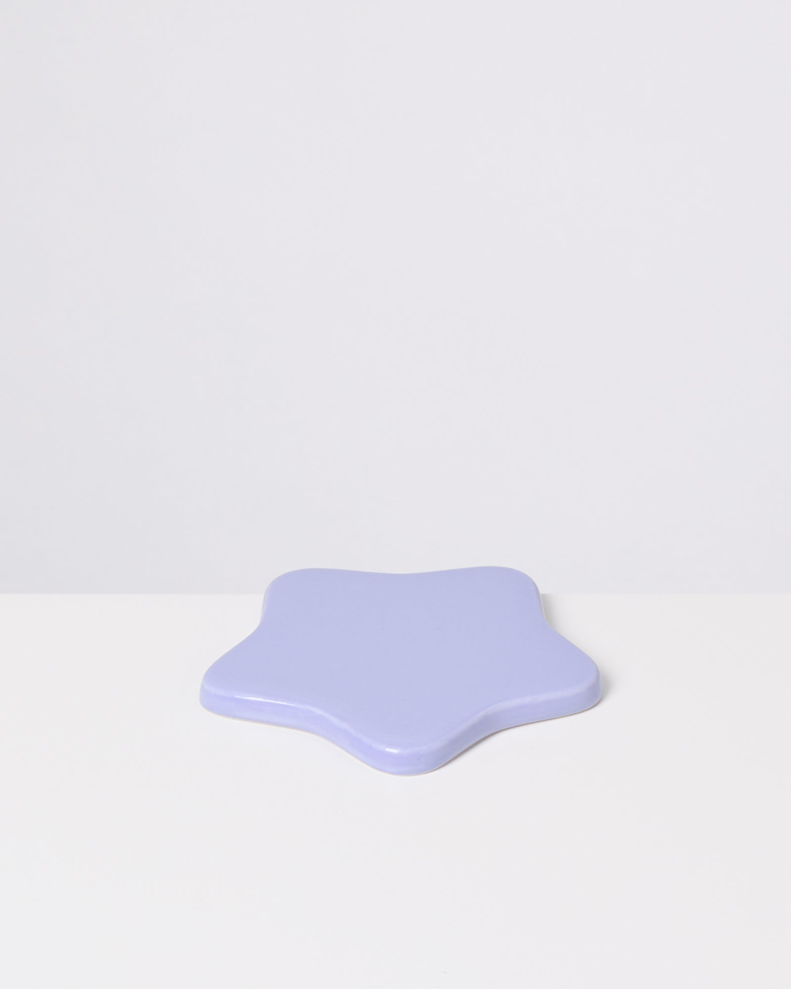 Lila, sternförmiger Gegenstand auf weißem Hintergrund.