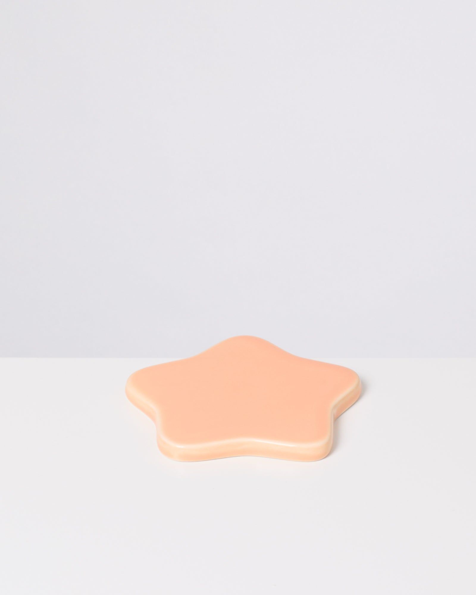 Beigefarbener sternförmiger Gegenstand auf einem weißen Hintergrund.