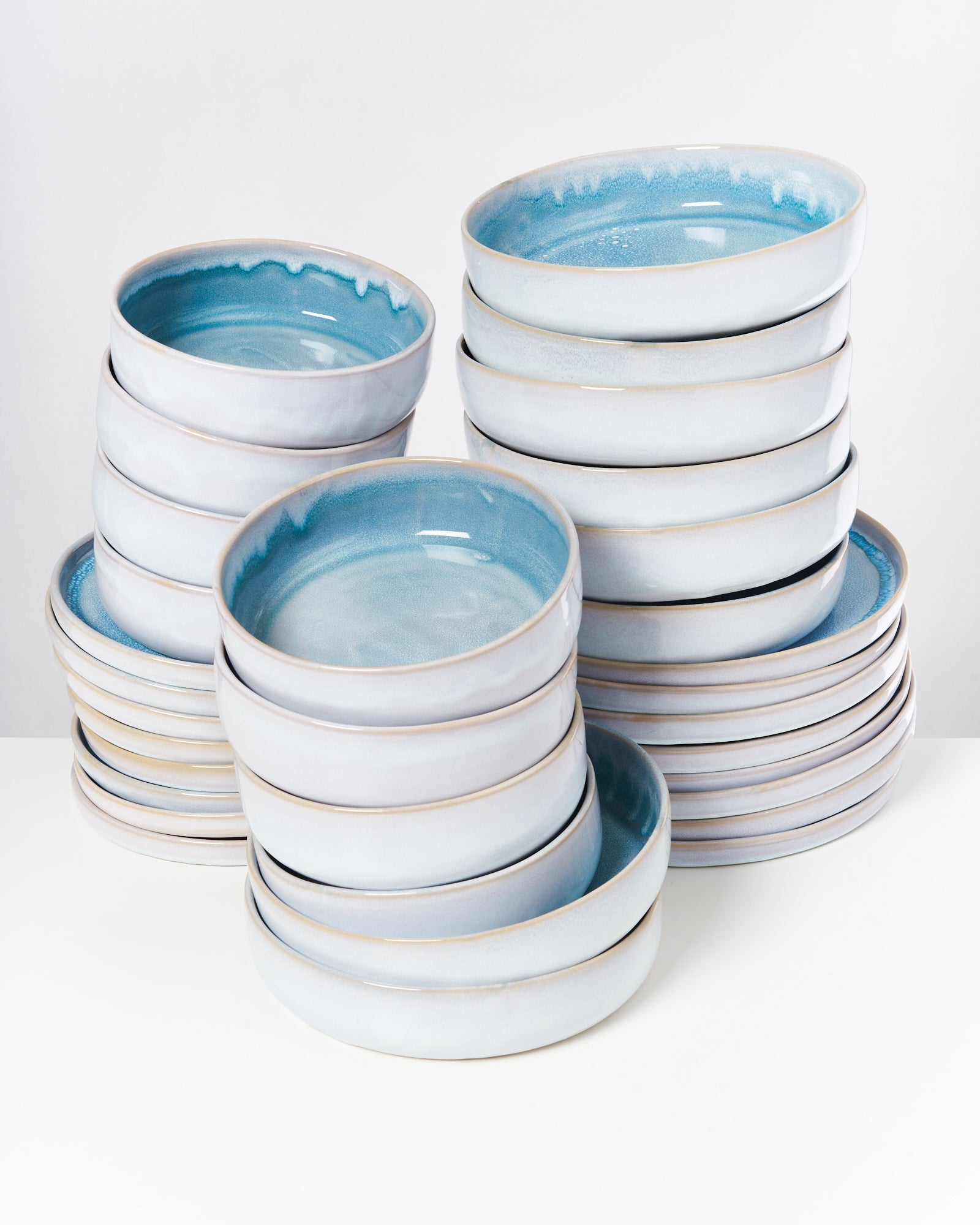 Stapel von blauen, glasierten Keramikschalen auf weißem Hintergrund.