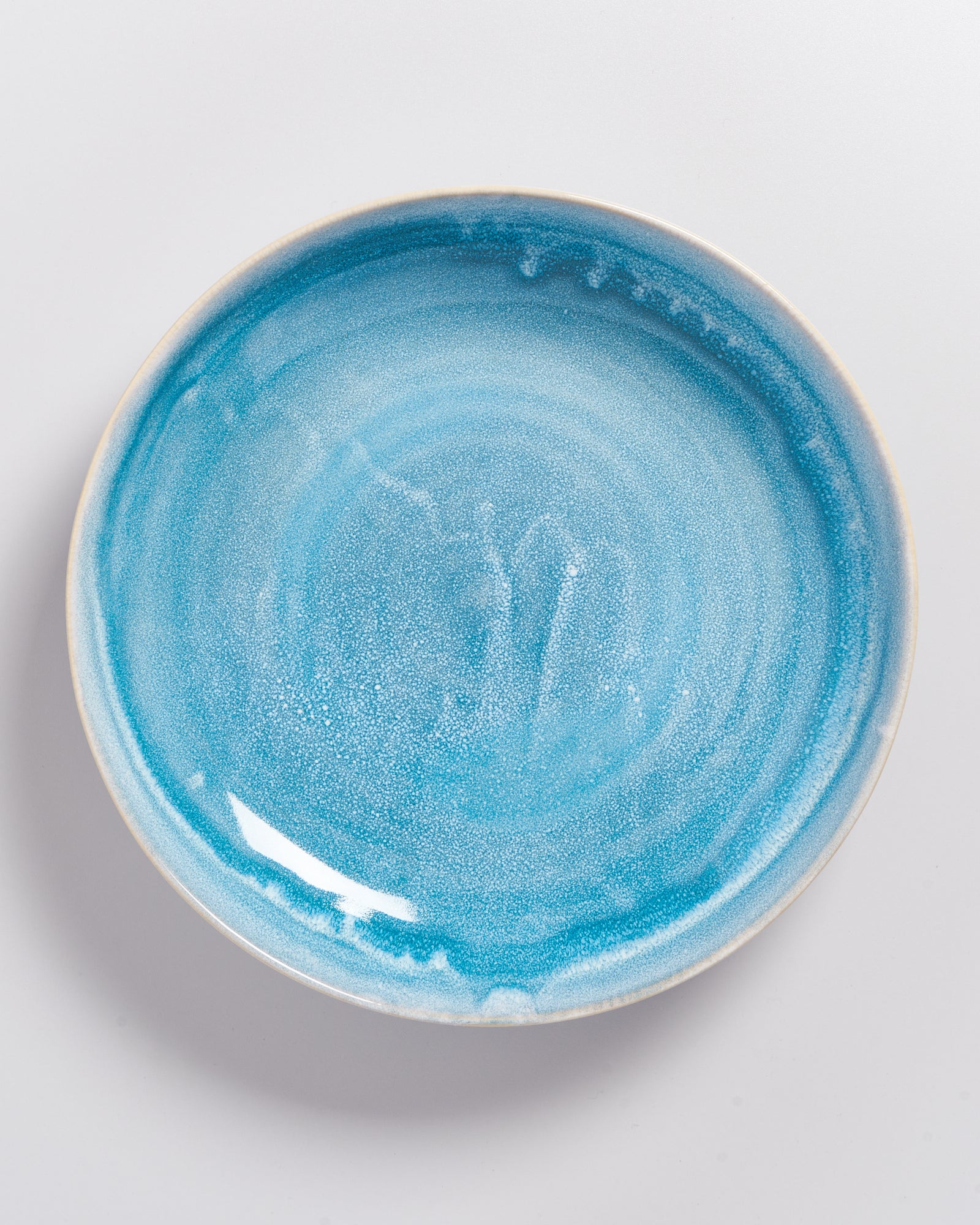 Keramikteller in verschiedenen Blautönen mit glatter Oberfläche auf einem weißen Hintergrund.