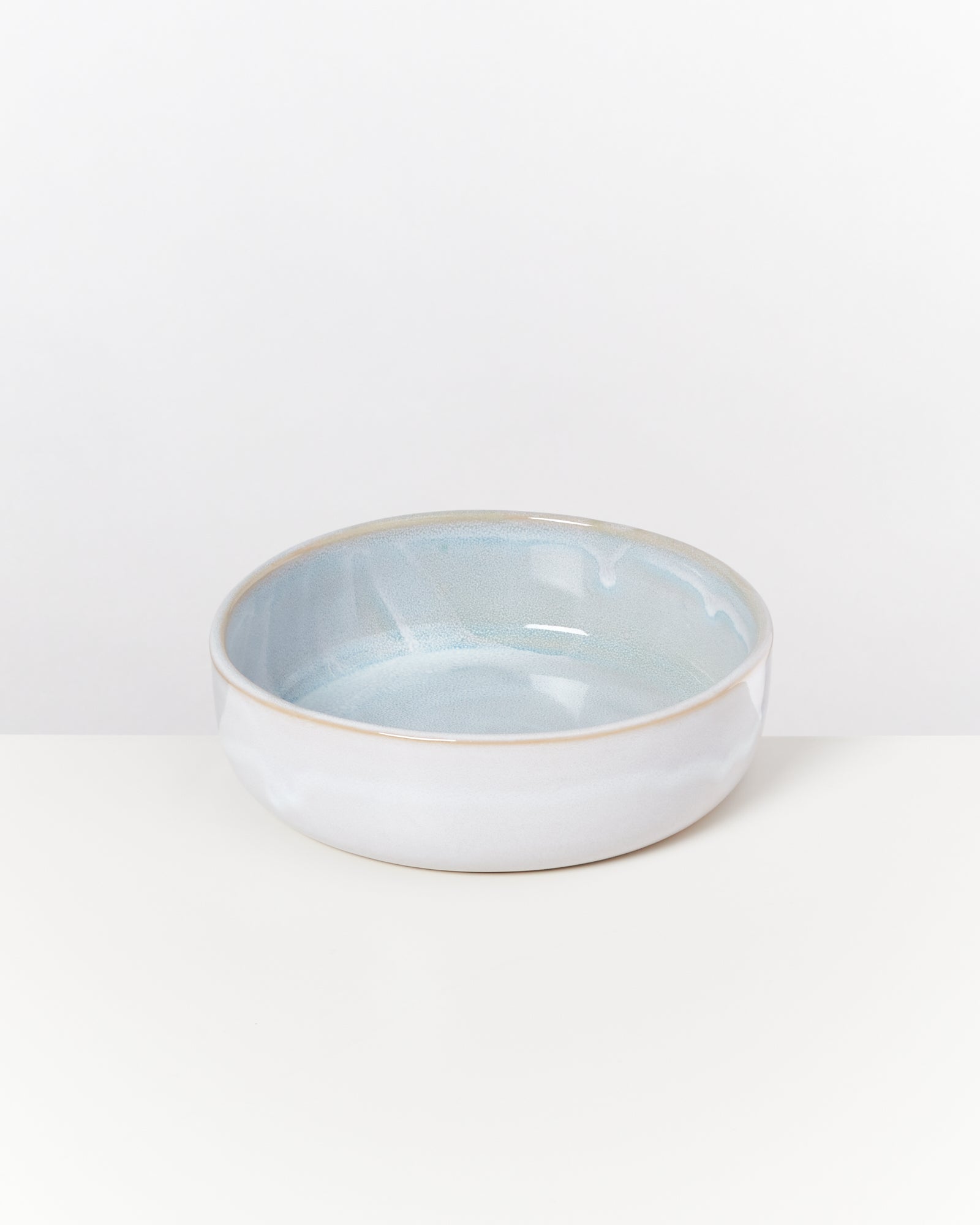 Eine runde, blau-weiße Keramikschale auf einem weißen Hintergrund.