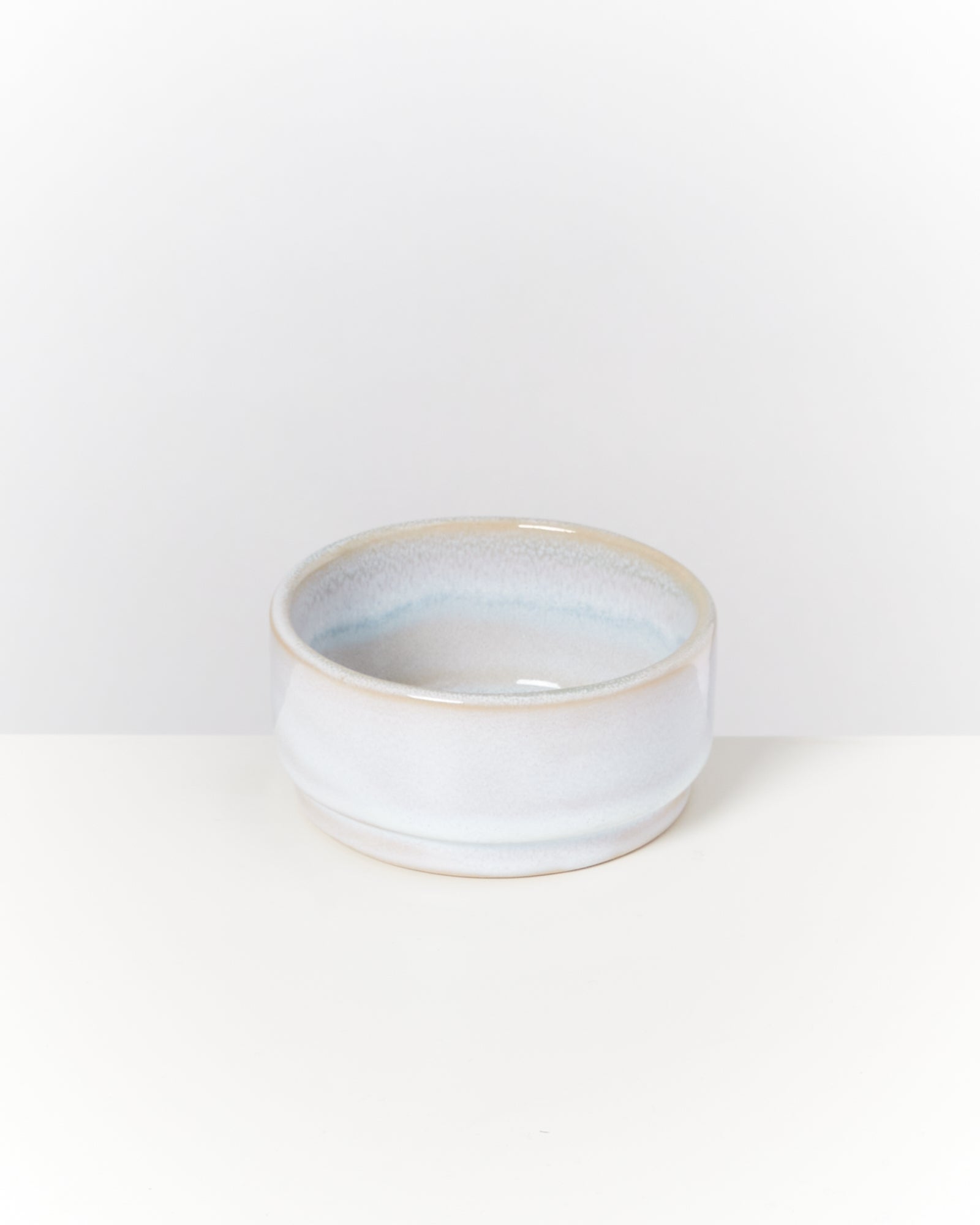 Keramikschale mit blauer Glasur auf einem weißen Hintergrund.