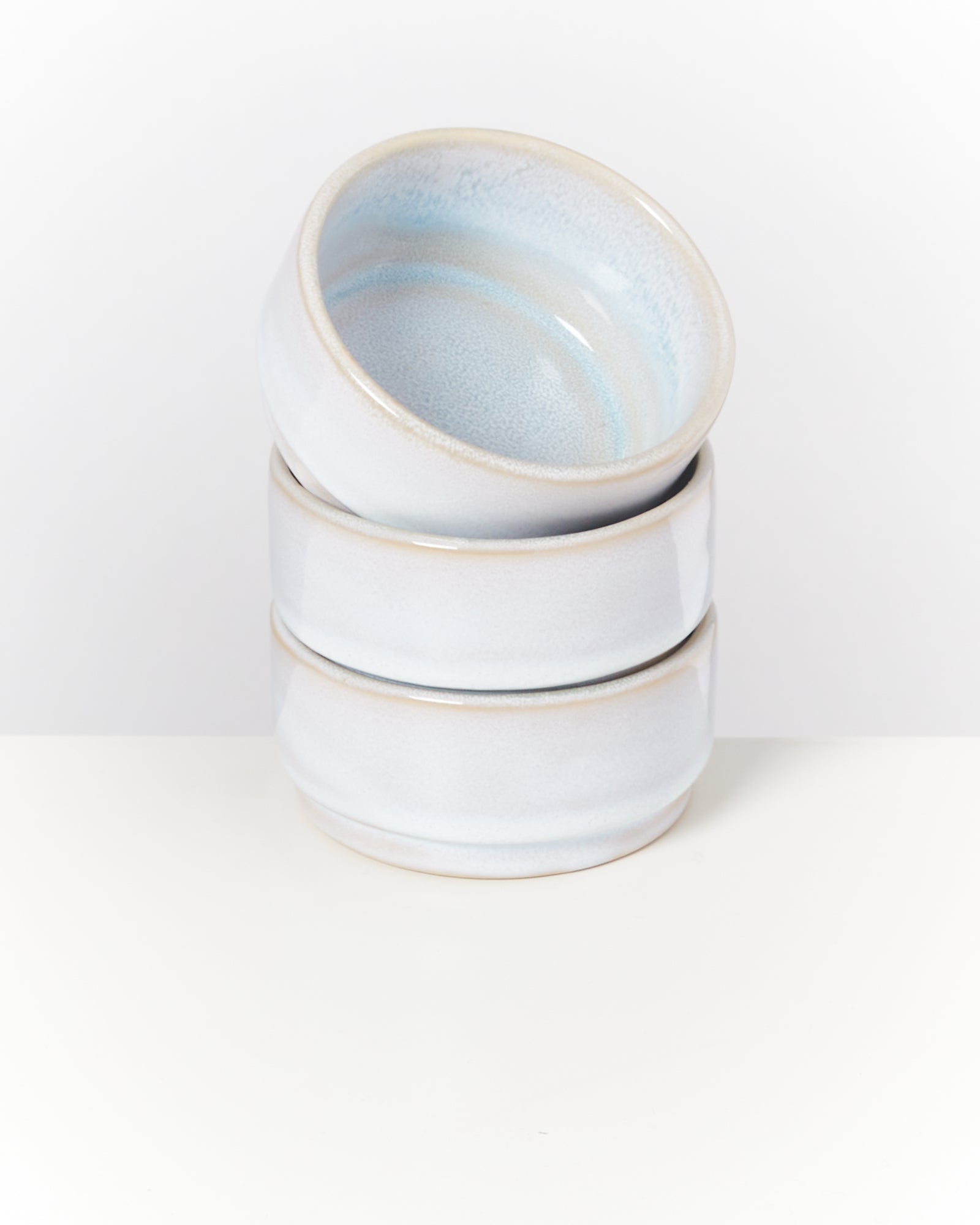 Drei gestapelte weiße Keramikschalen auf einem weißen Hintergrund.