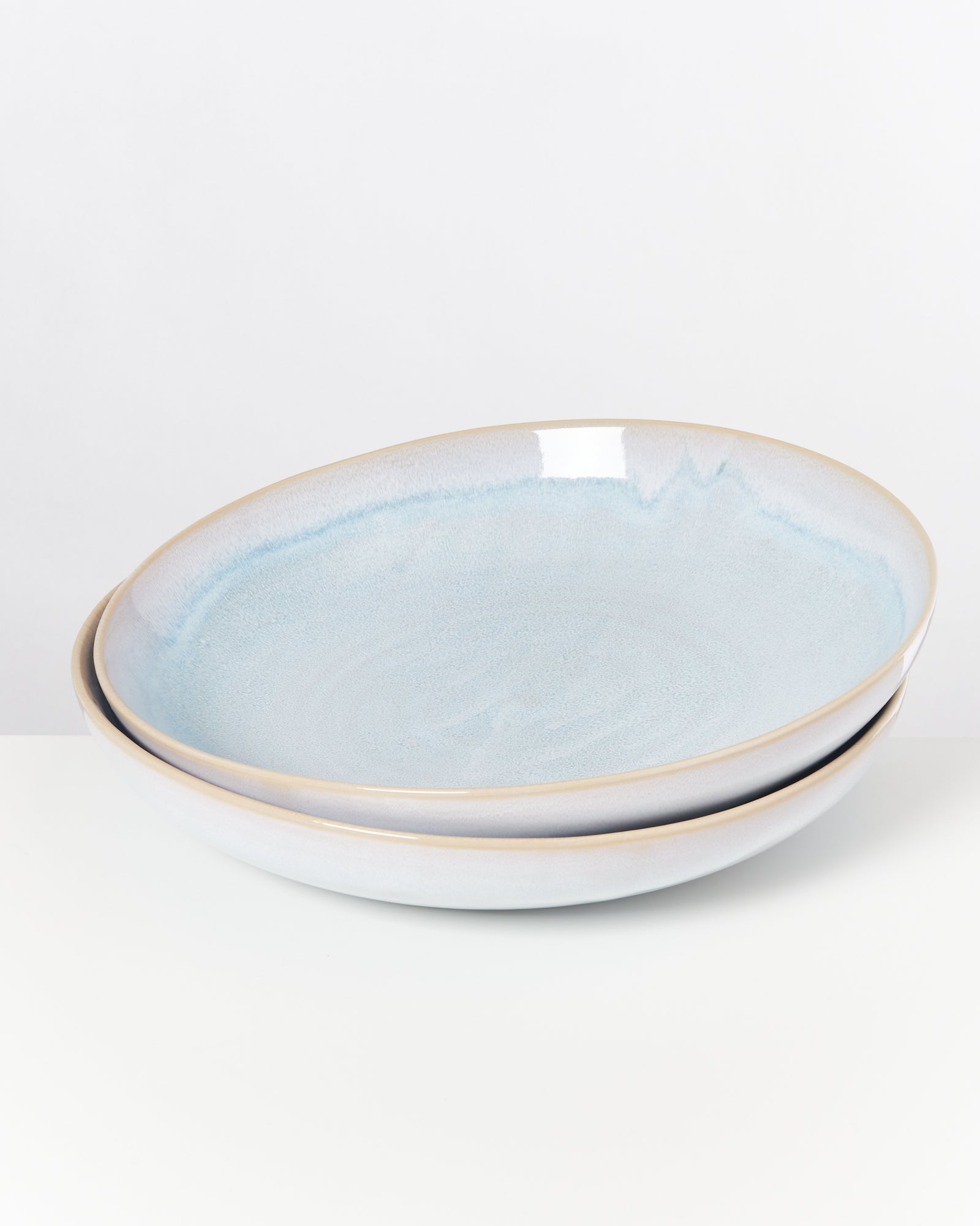 Zwei hellblaue Keramikschalen mit leichtem Glanz auf einem weißen Hintergrund.