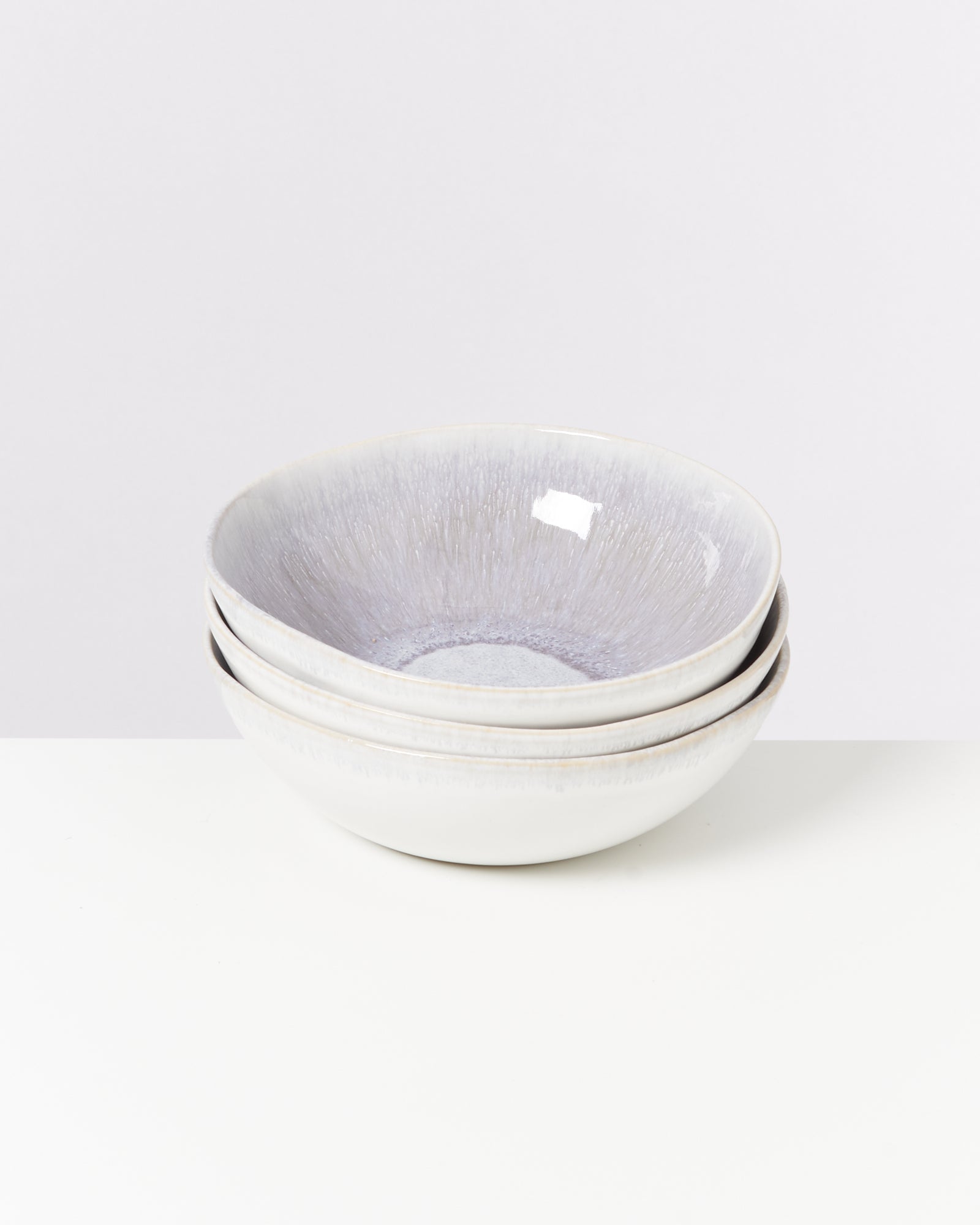 Drei gestapelte, hellgraue Schalen auf einem weißen Hintergrund.