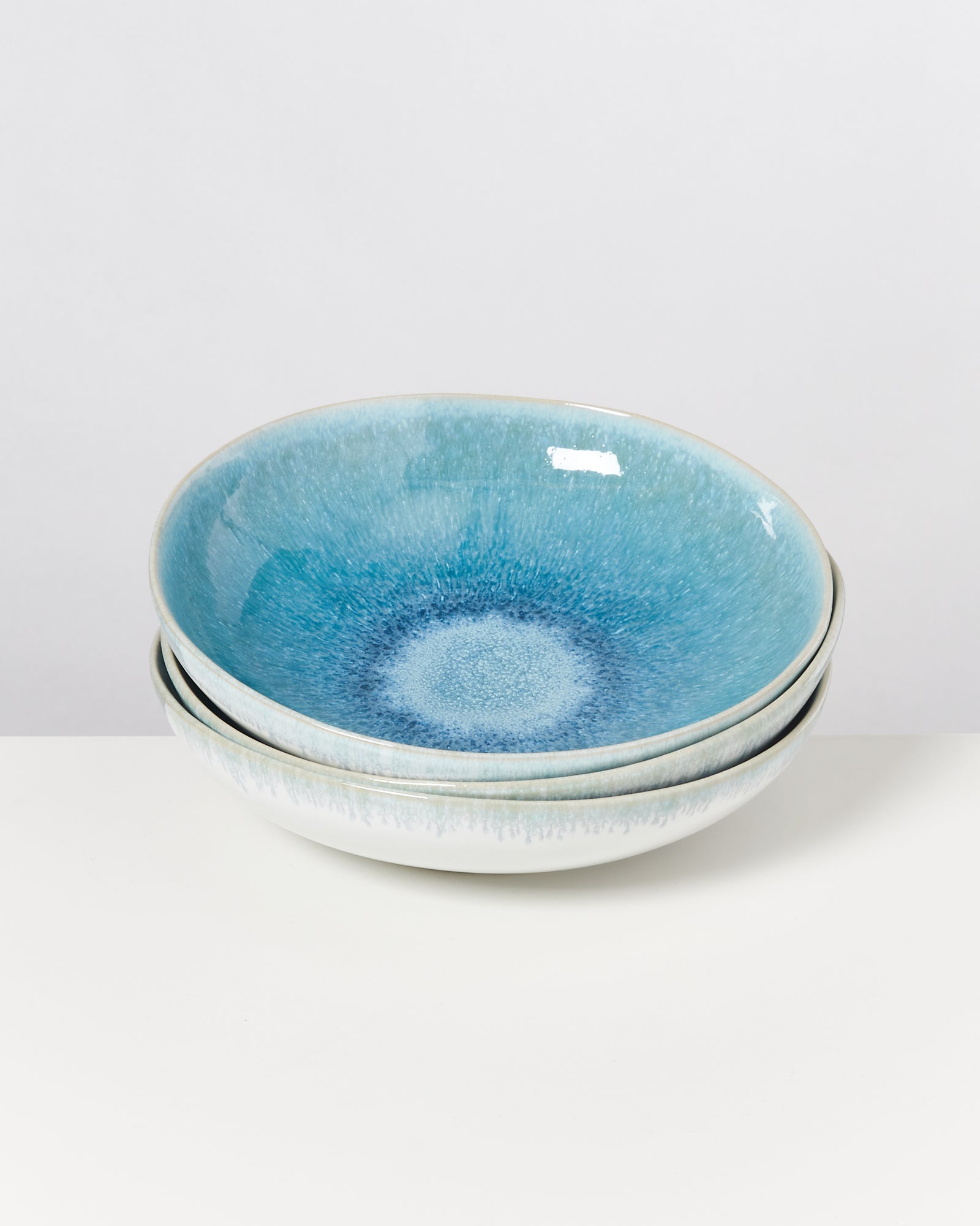 Drei blaue Keramikschalen mit einem dekorativen Muster sind aufeinander gestapelt.