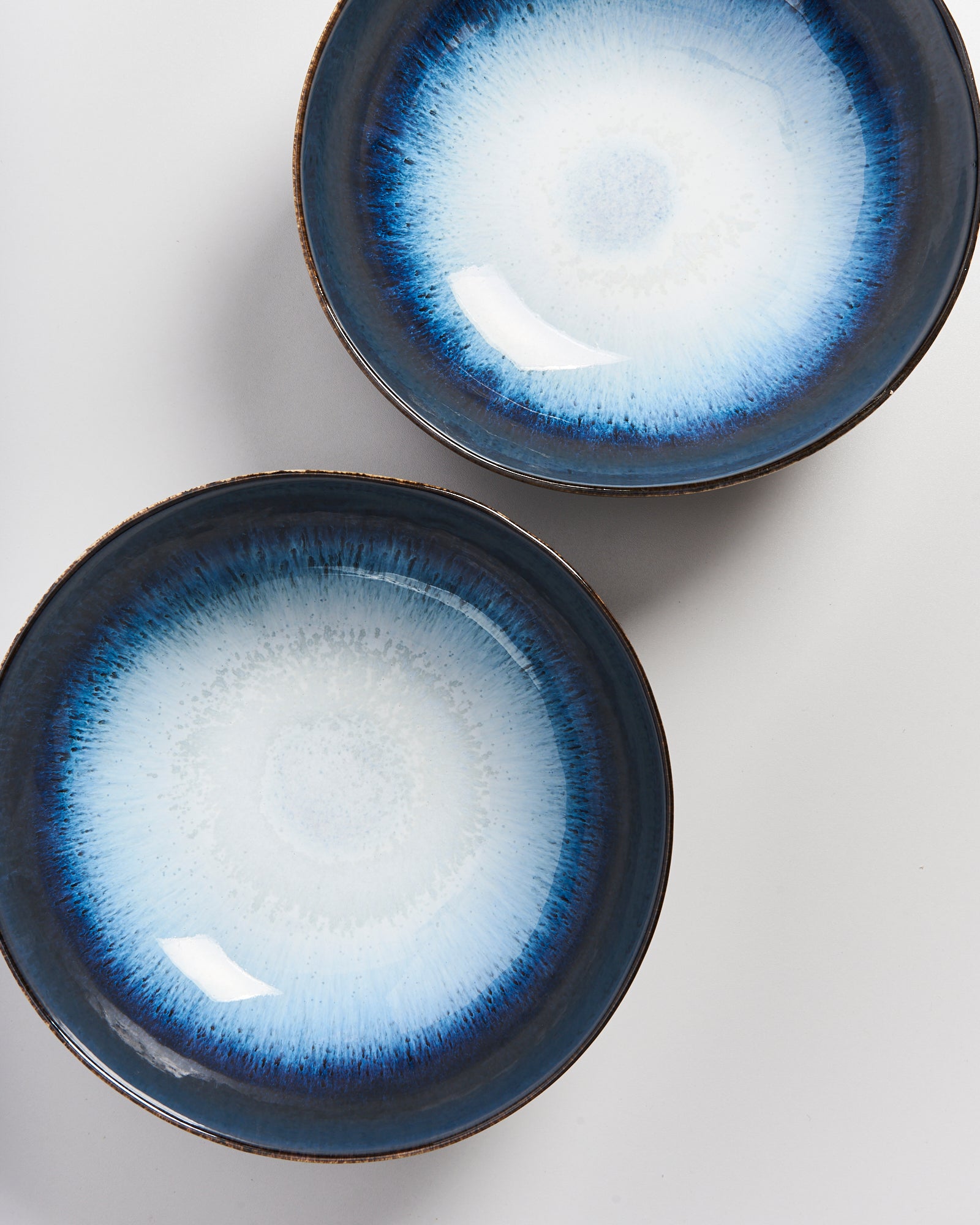 Zwei blau-weiße Keramikschalen mit einem konzentrischen Design auf weißem Hintergrund.