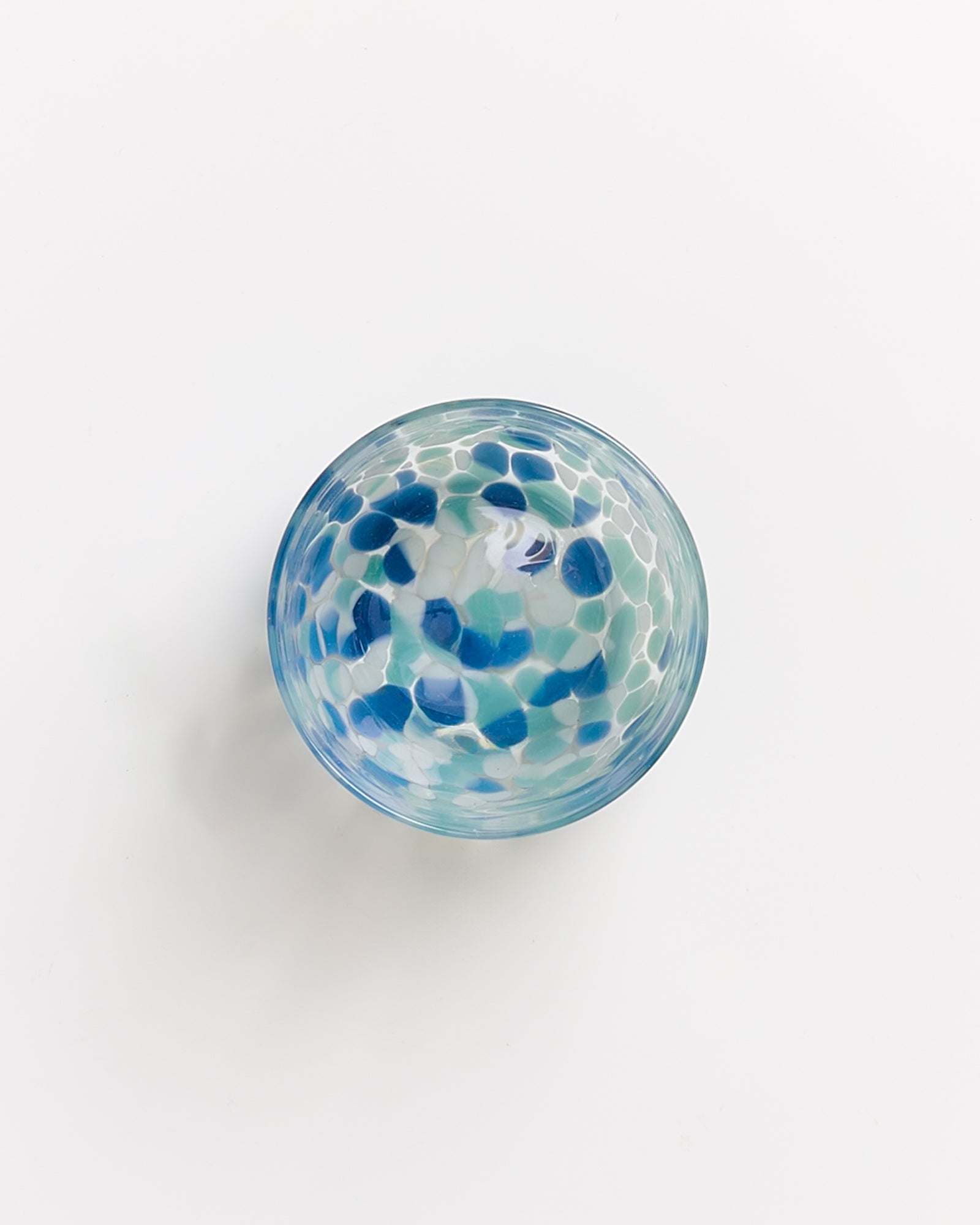 Obenansicht einer bunten Schale mit blau-grünem Mosaikmuster auf weißem Hintergrund.