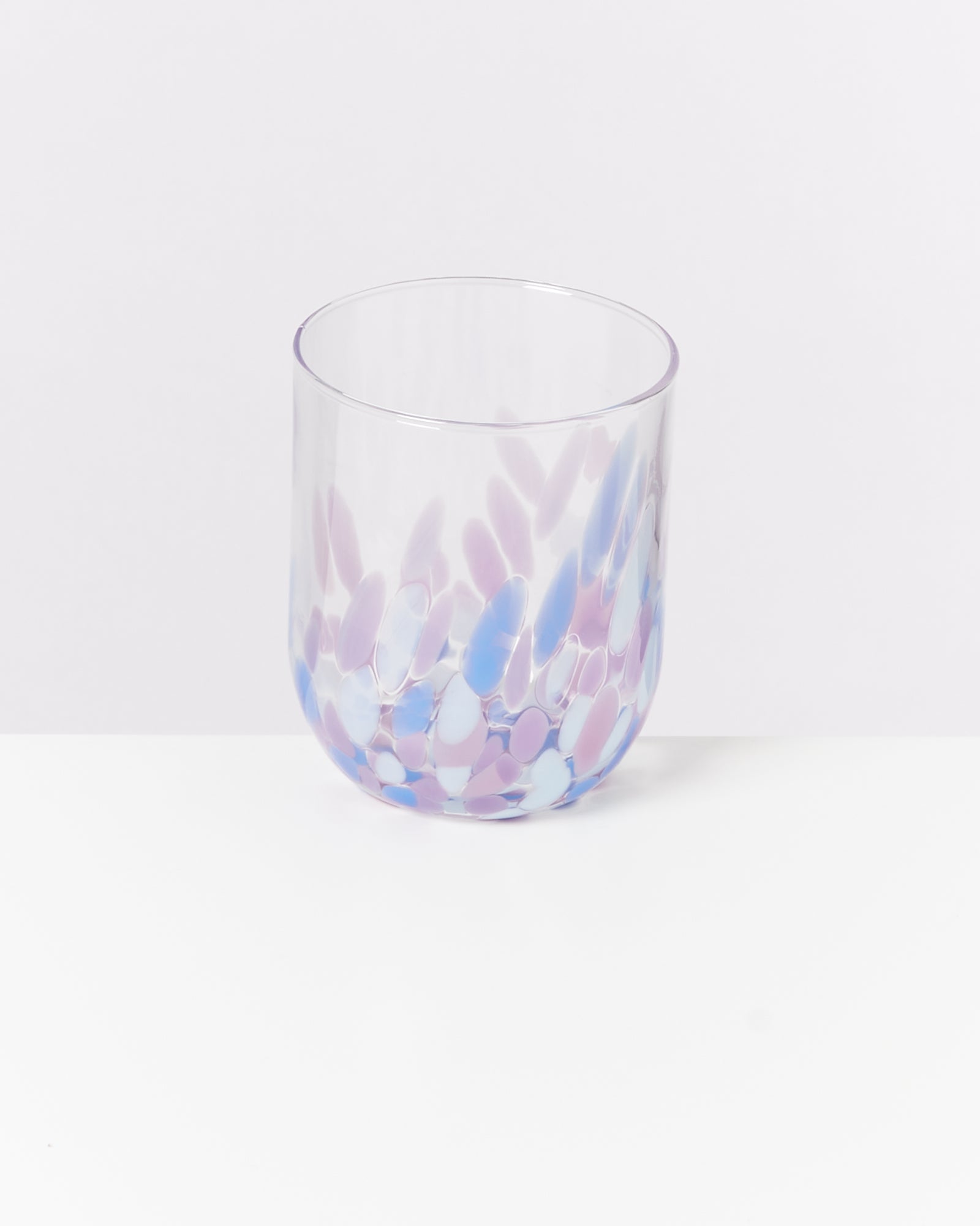 Transparenter Trinkbecher mit lila und blauen tupfenartigen Mustern auf weißem Hintergrund.