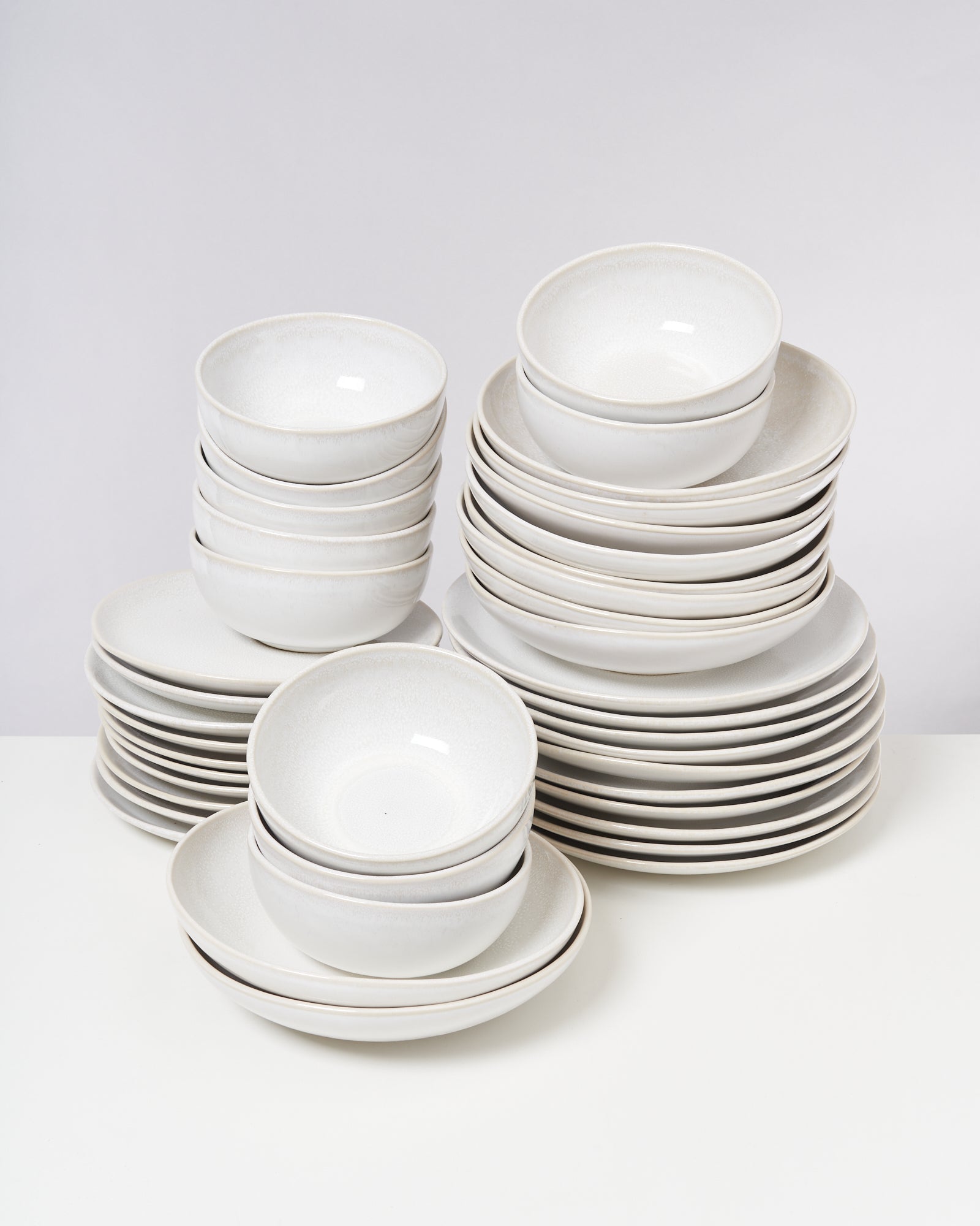 Ein Stapel weißer Porzellanschüsseln und -teller auf einem Tisch.