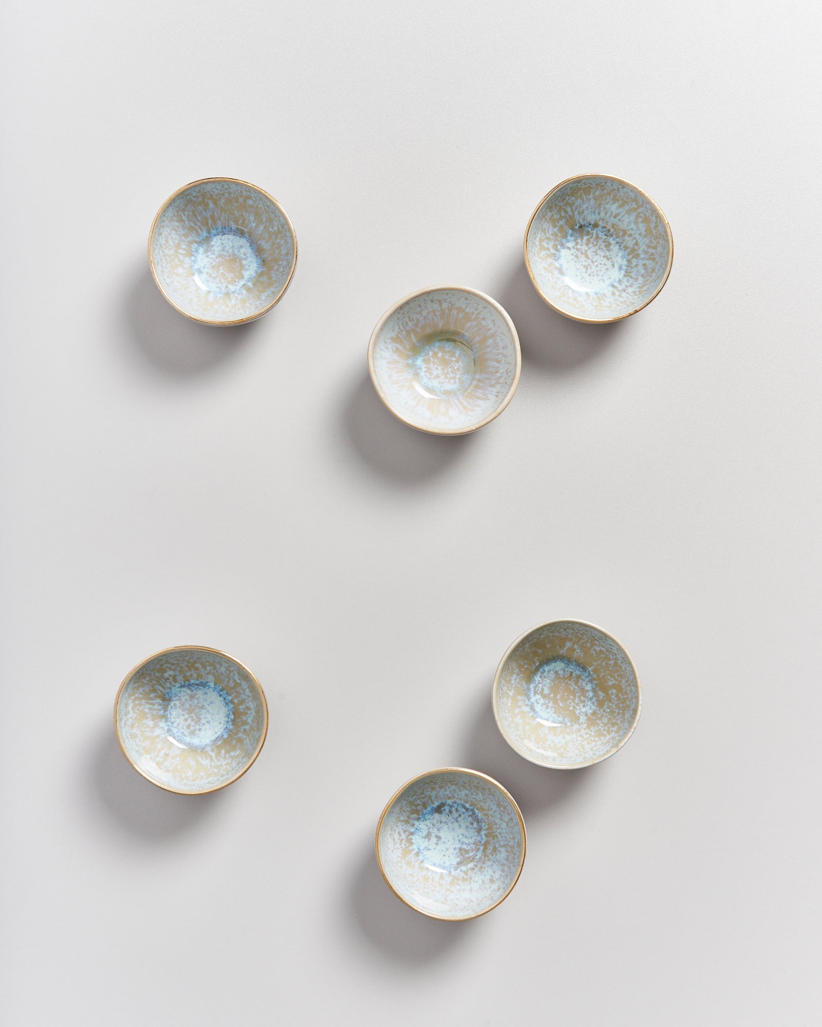 Sechs kleine, gemusterte Schalen auf einem weißen Hintergrund angeordnet.