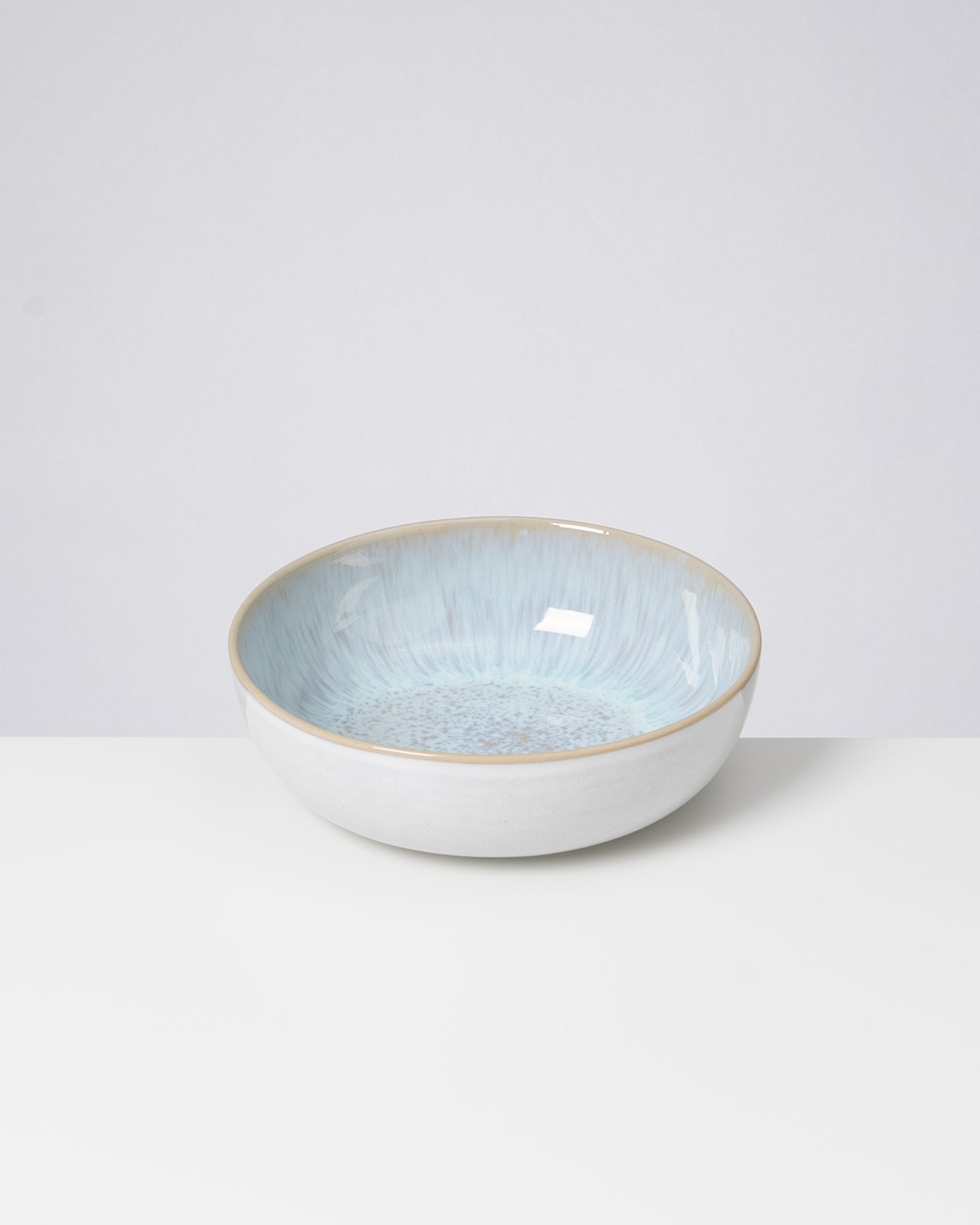 Keramikschale mit blauem Muster auf einem weißen Untergrund.