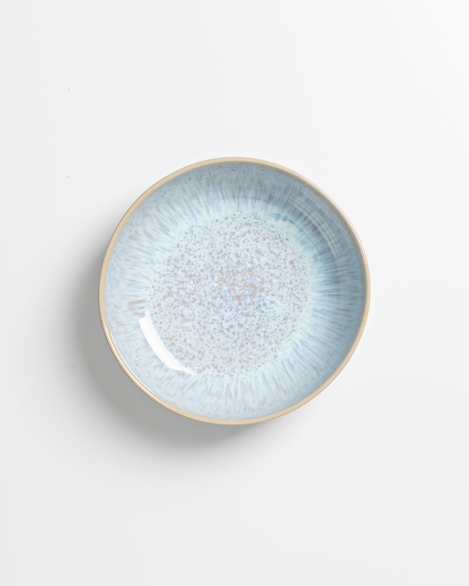 Keramikteller mit blauem, gesprenkeltem Muster auf weißem Hintergrund.