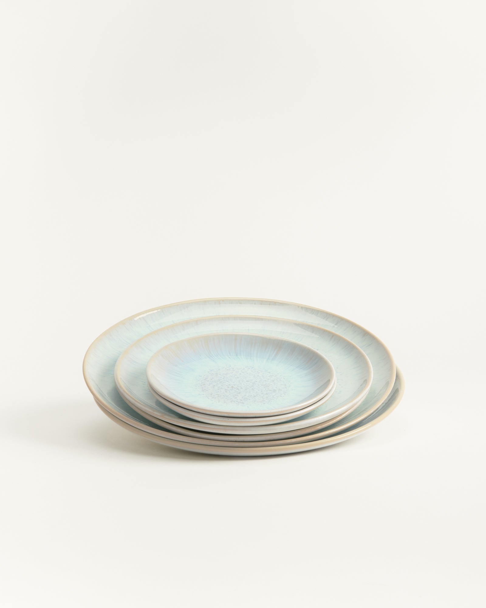 Ein Stapel von vier blauen Keramiktellern in verschiedenen Größen auf einem weißen Hintergrund.