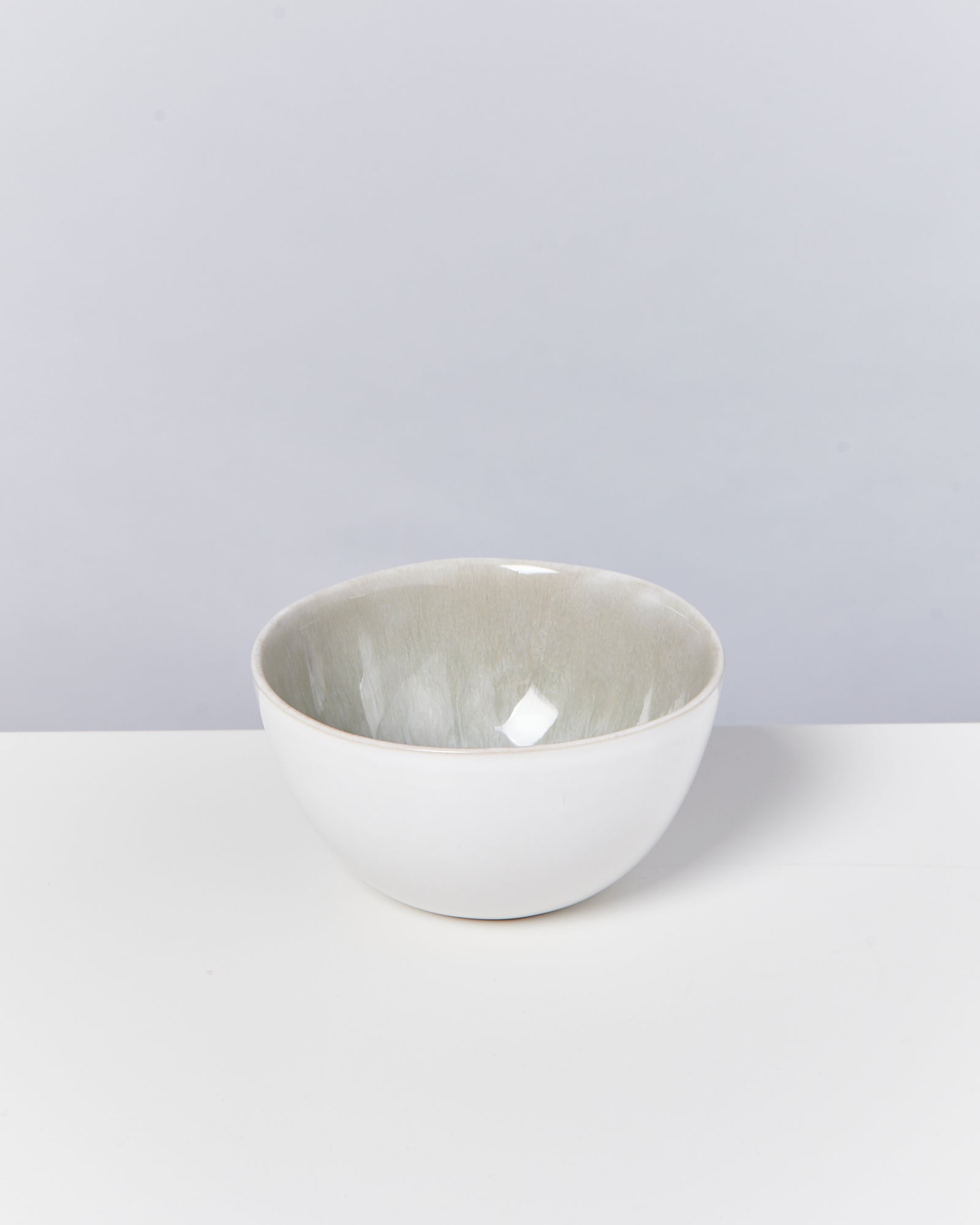 Weiße Schüssel mit grauer Innenseite auf weißem Hintergrund.