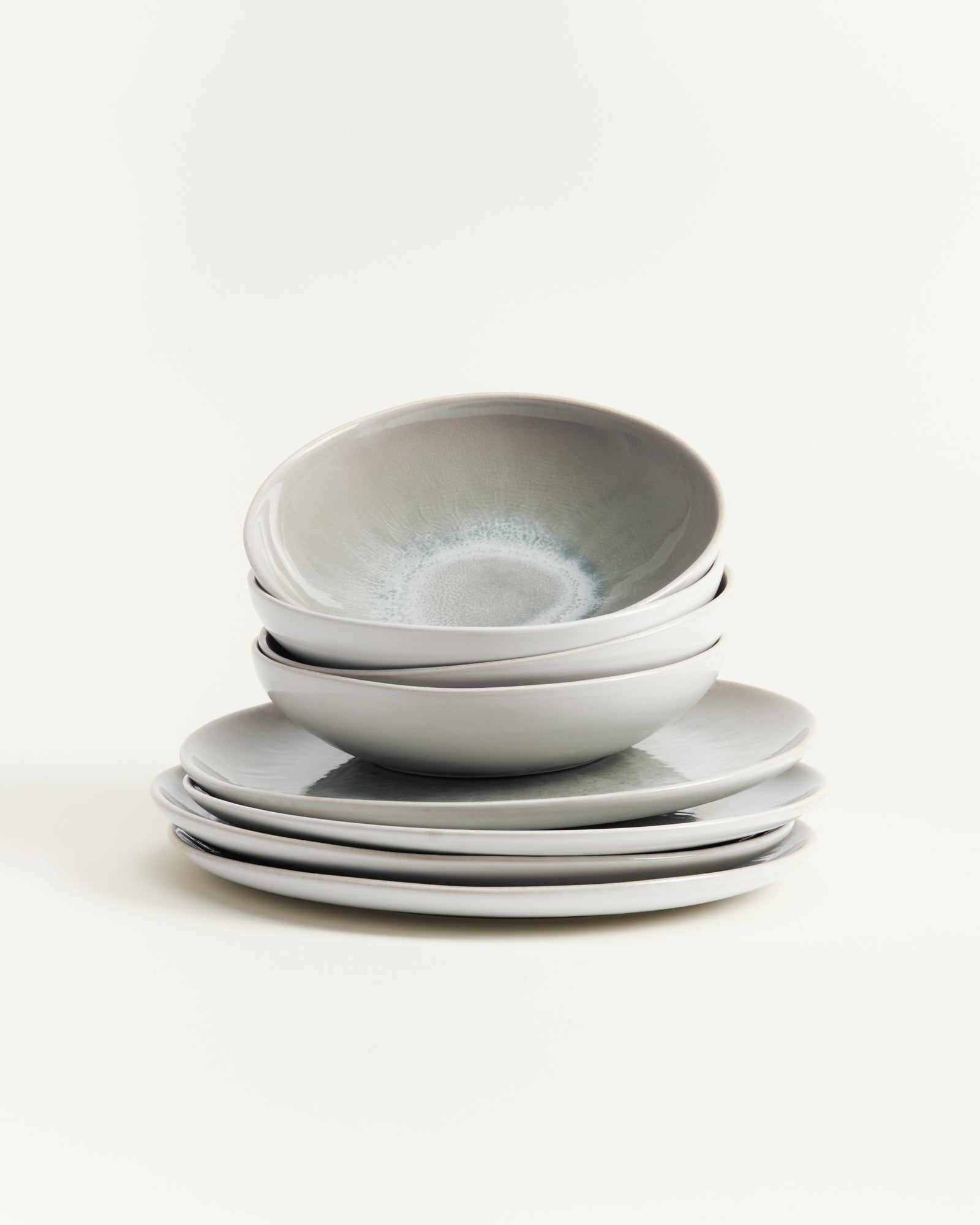 Ein Stapel grauer Keramikschalen und Teller auf einem hellen Hintergrund.