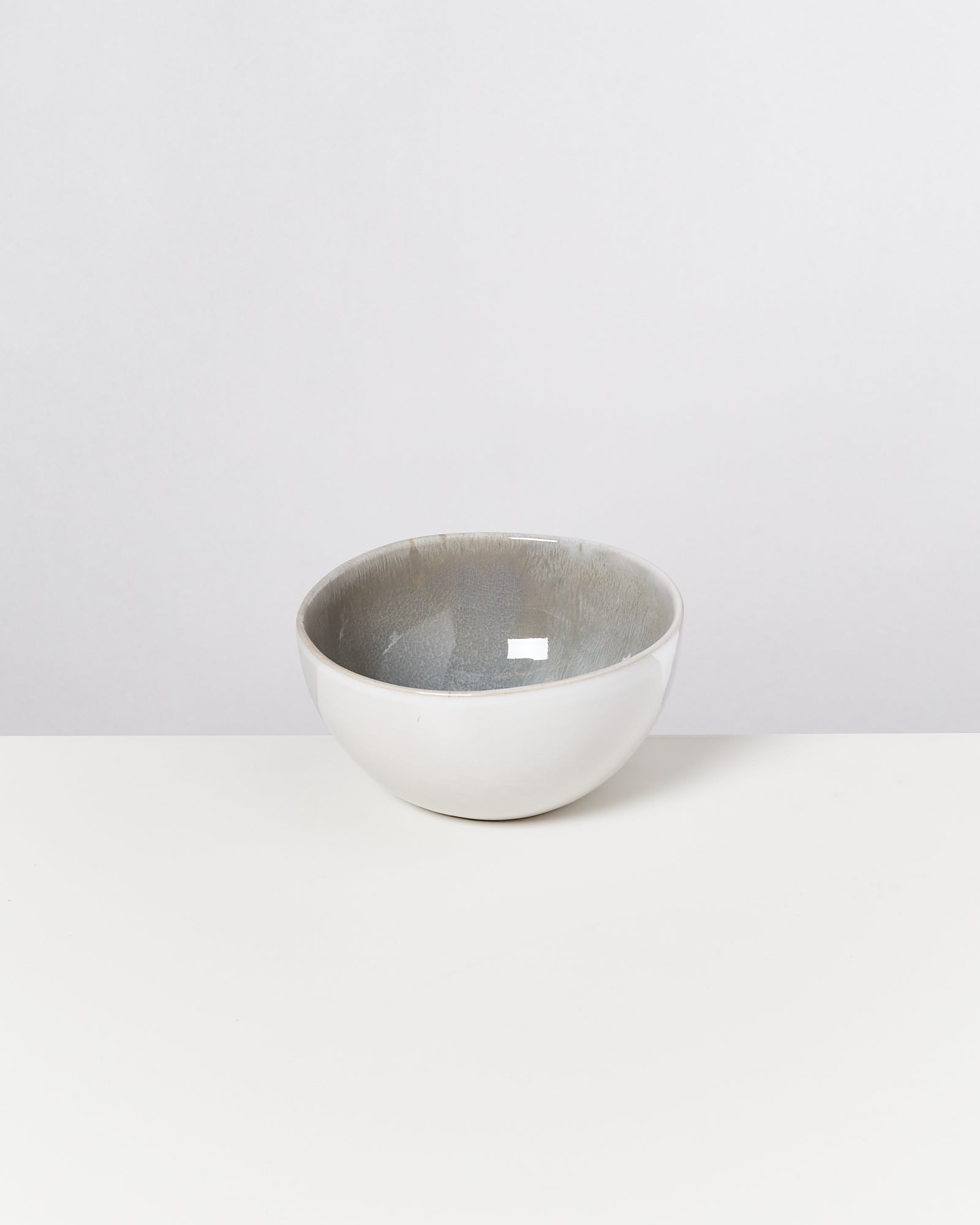 Weiße Keramikschale mit grauer Innenseite auf einem weißen Hintergrund.