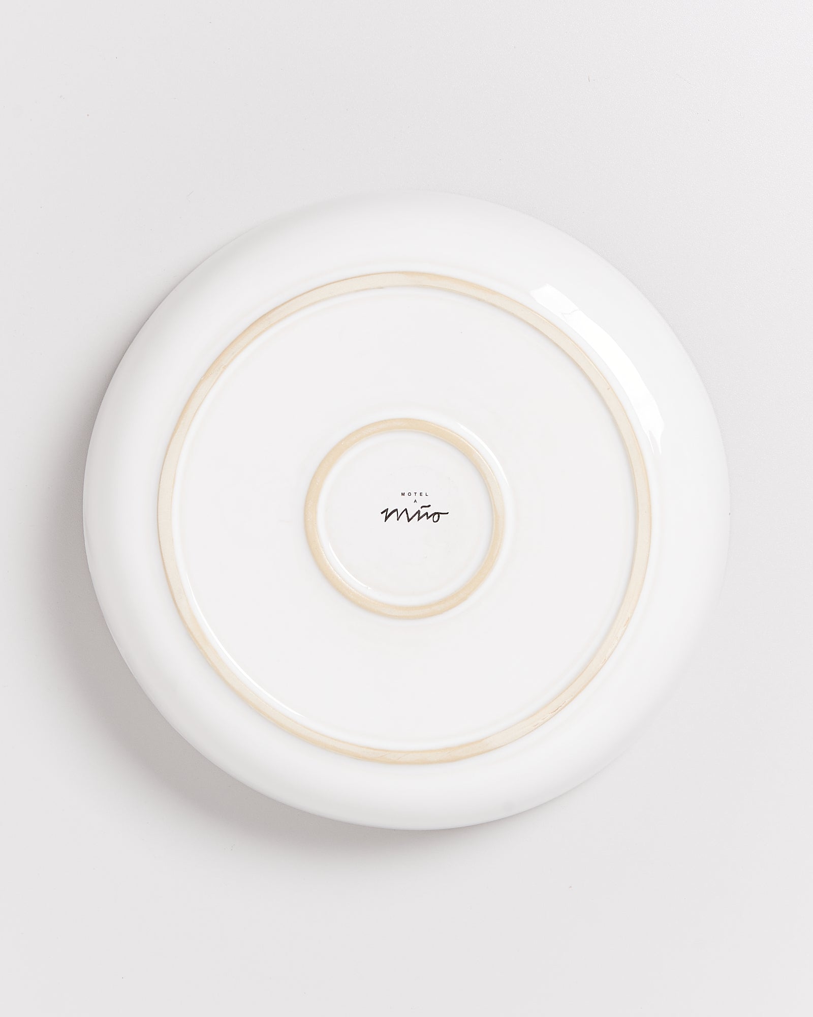 Rückseite eines weißen Tellers mit dem Aufdruck "Hotel Miró" in der Mitte.