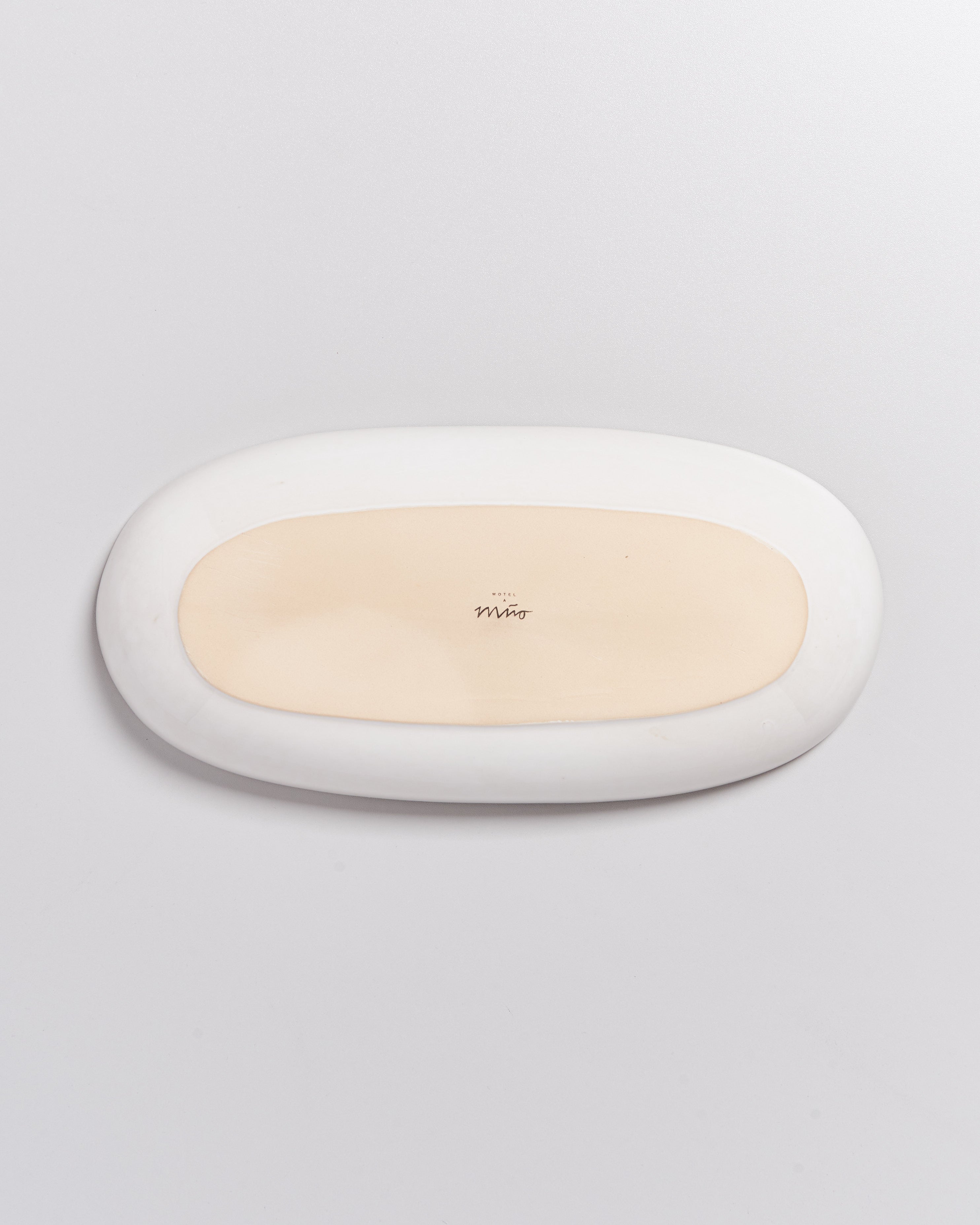 Ovaler, zweifarbiger Teller auf weißem Hintergrund.