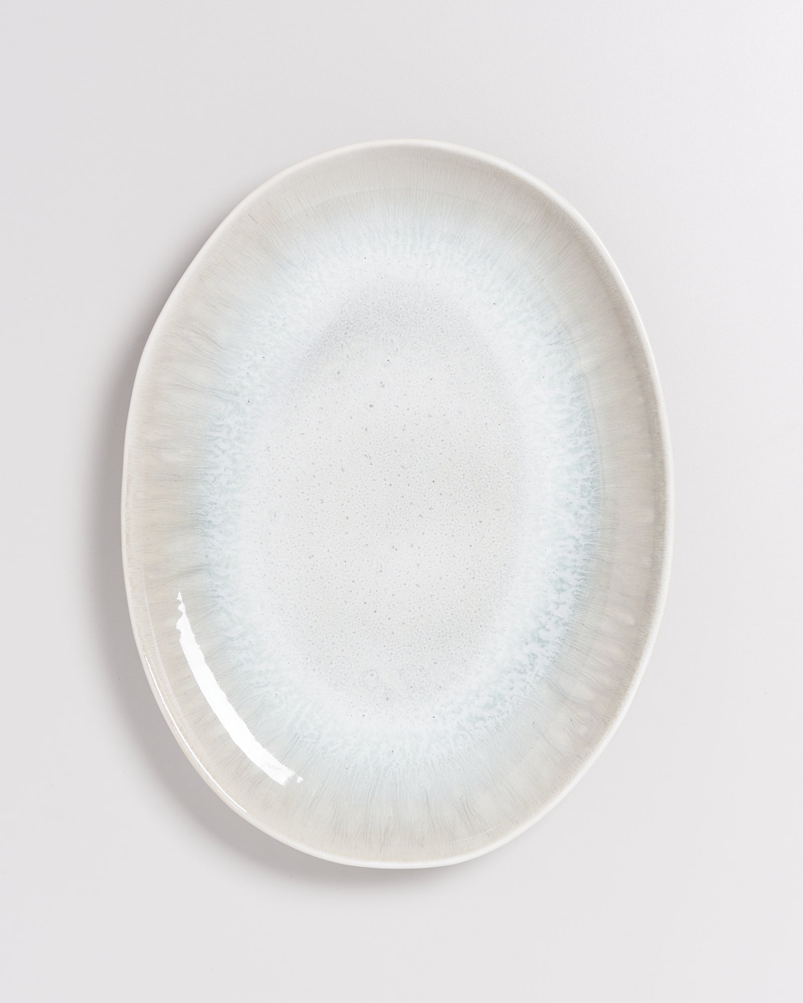 Ovalteller mit blau-weißem Farbverlauf auf hellem Hintergrund.