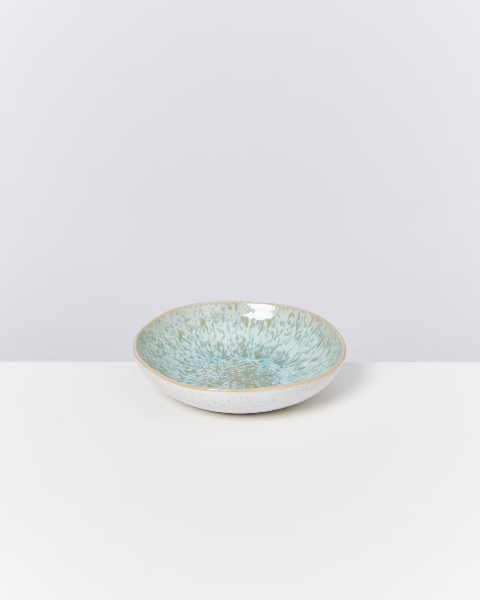 Keramikschüssel mit blauem Muster auf weißem Hintergrund.