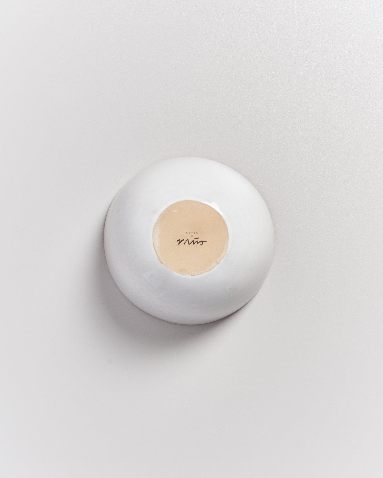 Weiße Schale mit beige-farbenem Boden und dem Schriftzug "Hotel Miró" auf weißem Hintergrund.