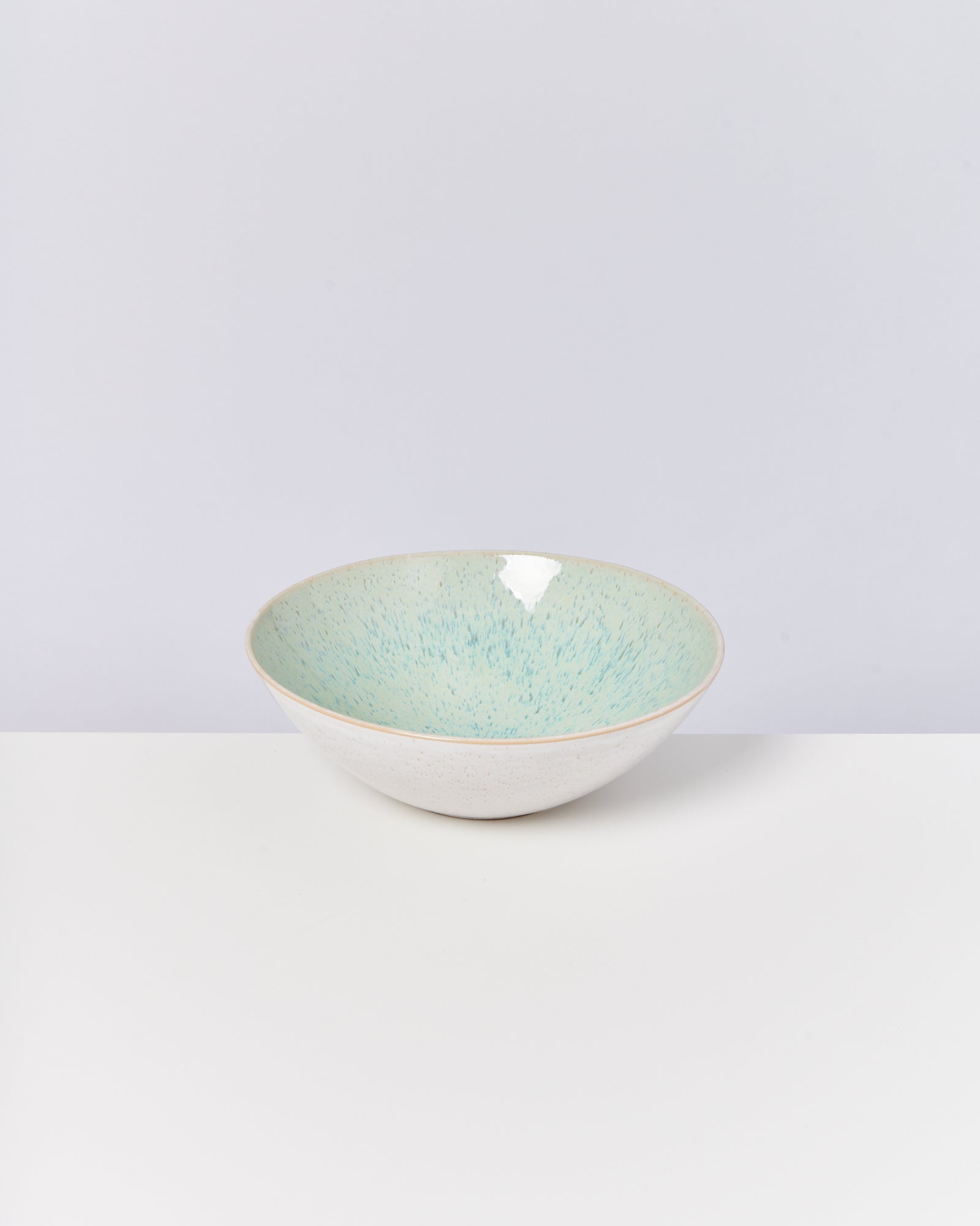 Keramikschale mit hellblauer Innenseite auf weißem Hintergrund.