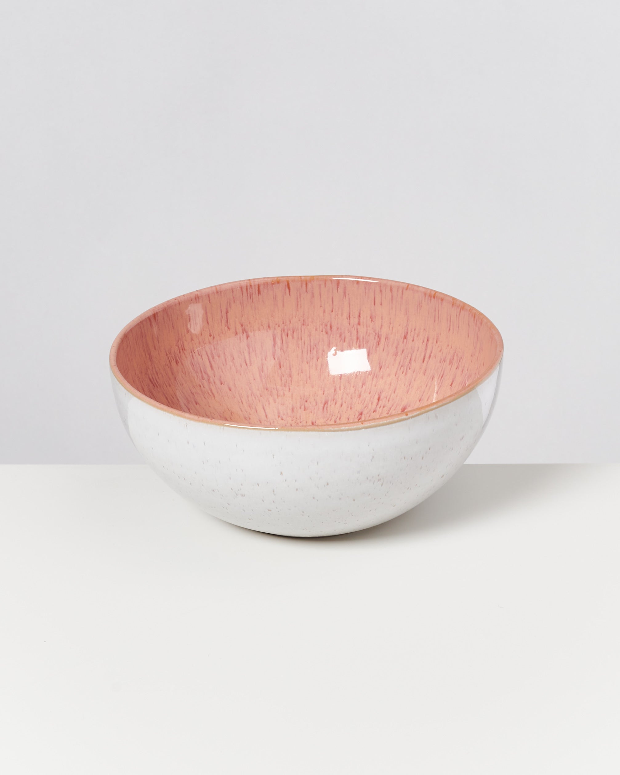 Rosa und weiße Keramikschüssel auf weißem Hintergrund.