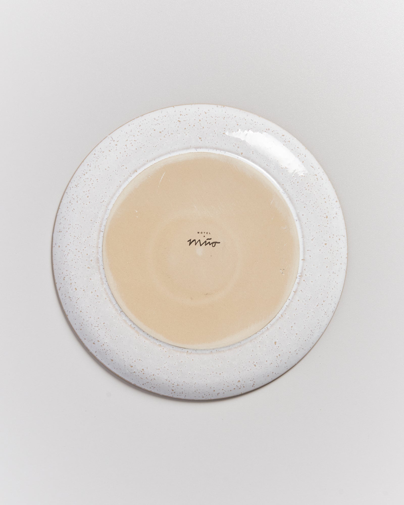 Unterseite eines Tellers mit der Aufschrift "Hotel Miro" auf einer weißen Oberfläche.
