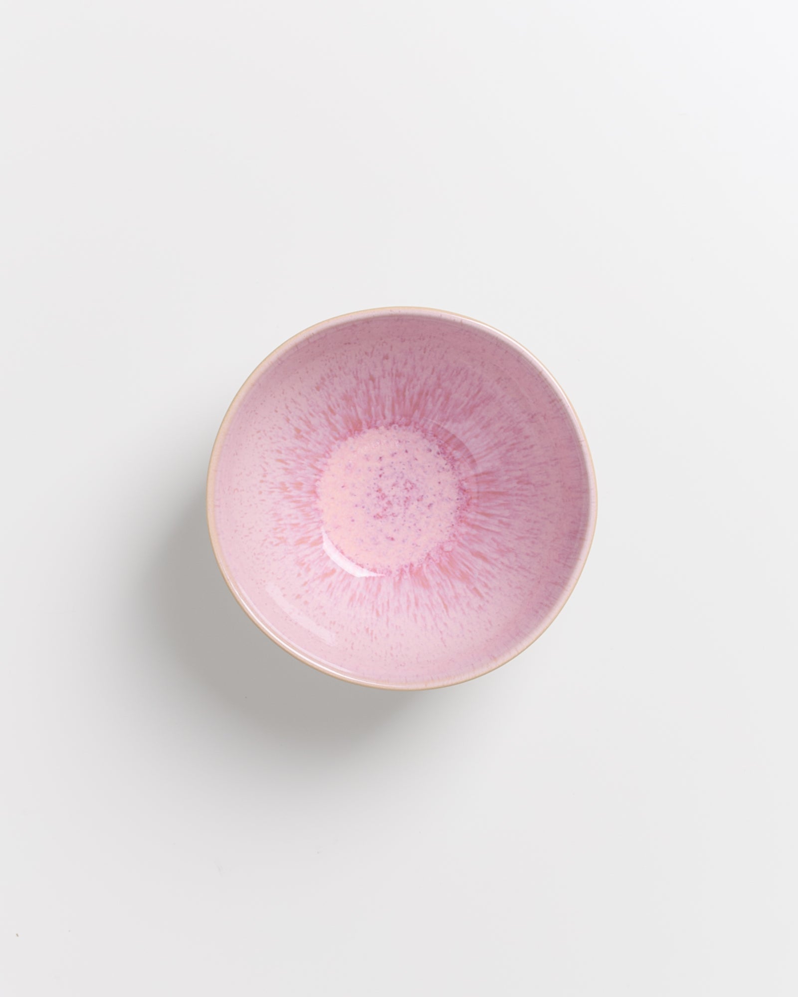 Rosa Schüssel vor weißem Hintergrund mit strahlenförmiger Textur im Inneren.