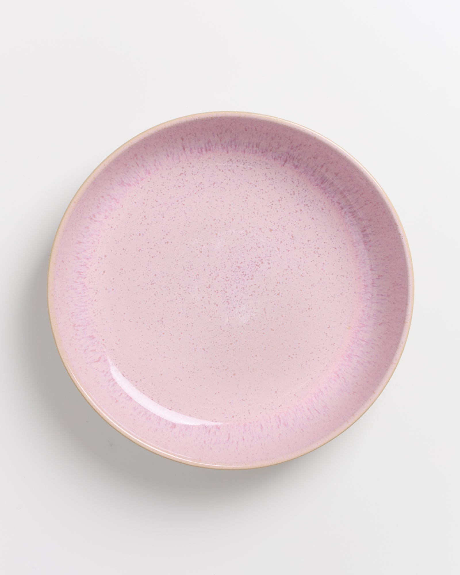 Runder, pastellrosa Teller mit gesprenkeltem Muster auf weißem Hintergrund.