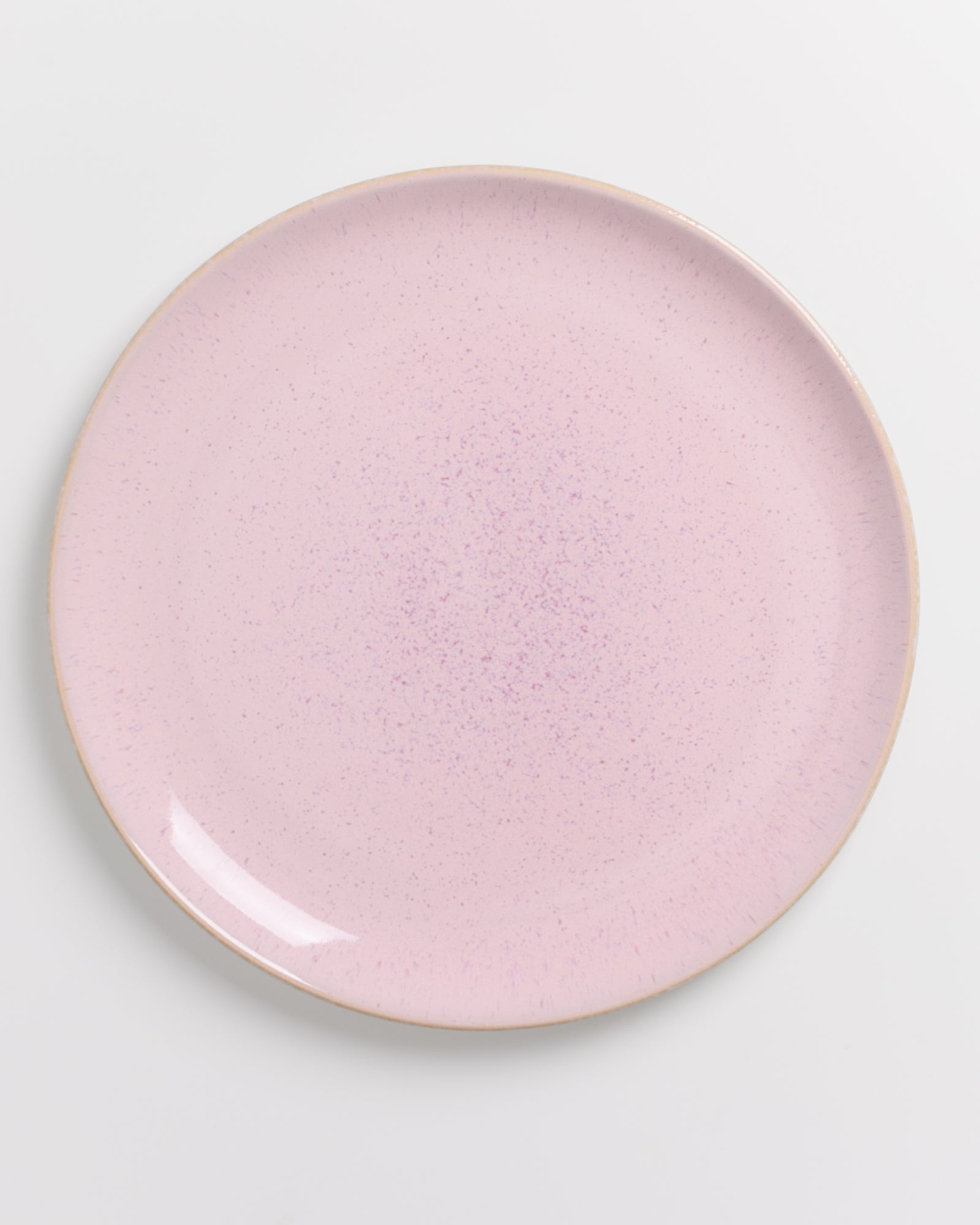 Ein runder, rosa Teller mit feiner Sprenkelung auf weißem Hintergrund.
