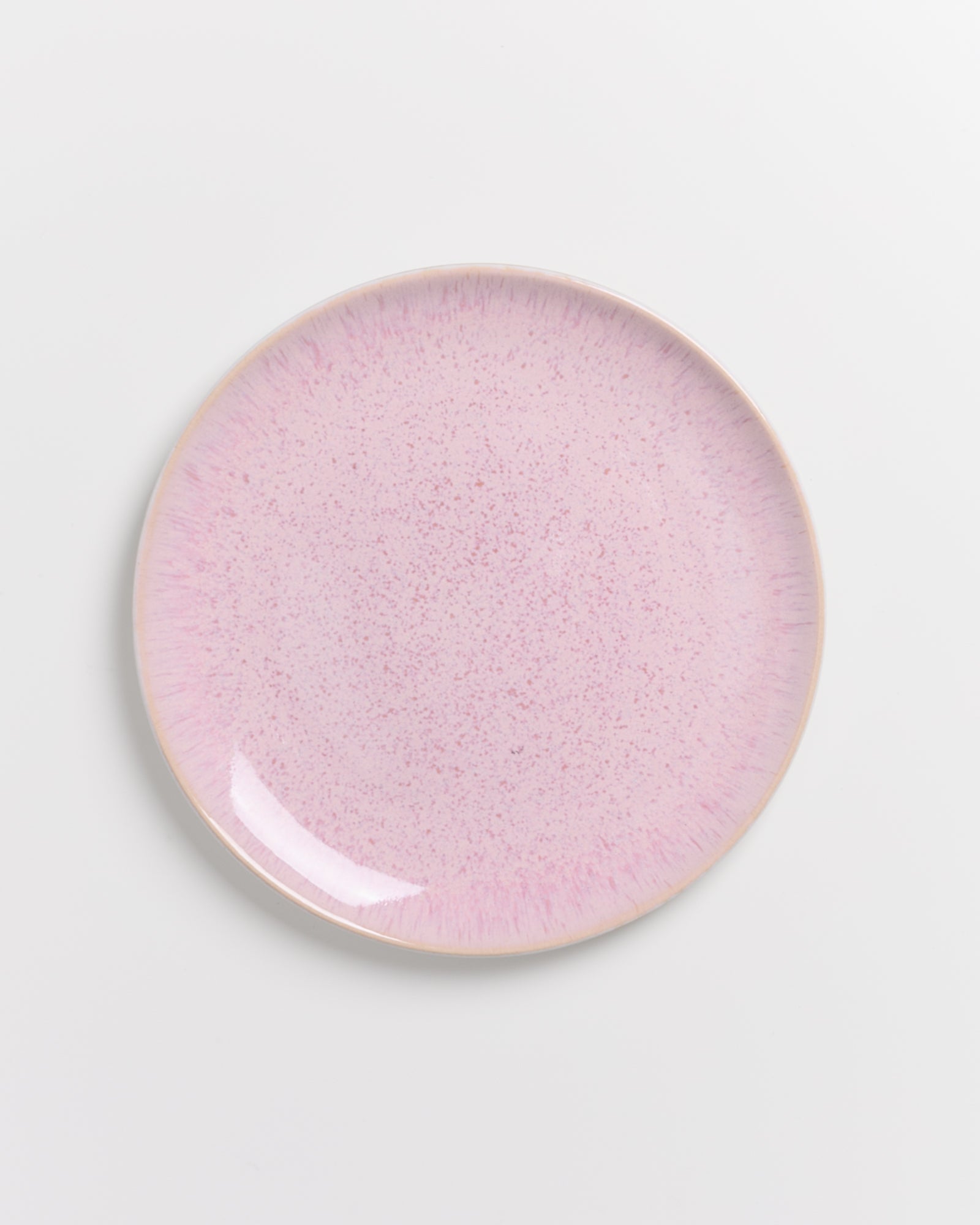 Rosa Keramikteller mit gesprenkeltem Muster auf weißem Hintergrund.