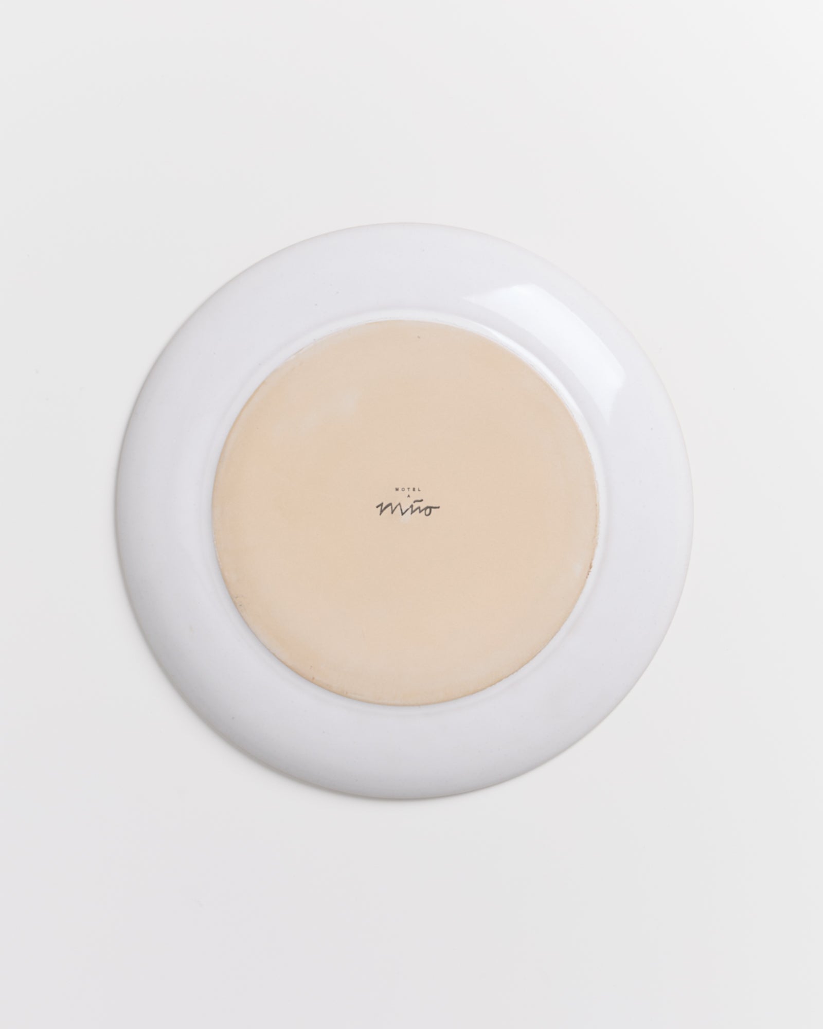 Umgedrehter Teller mit Aufschrift "Miro" auf hellem Hintergrund.