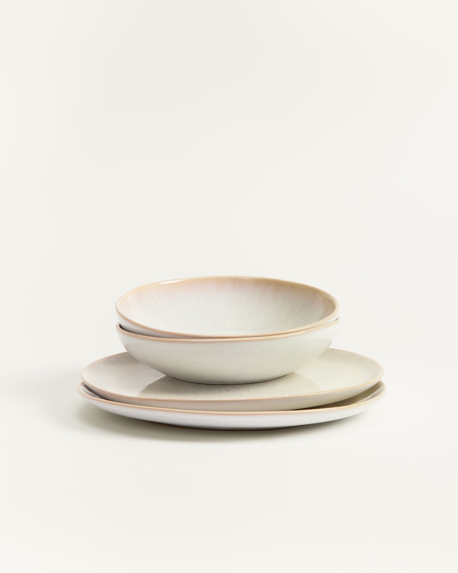 Ein Stapel aus zwei weißen Tellern und einer Schale auf einem weißen Hintergrund.