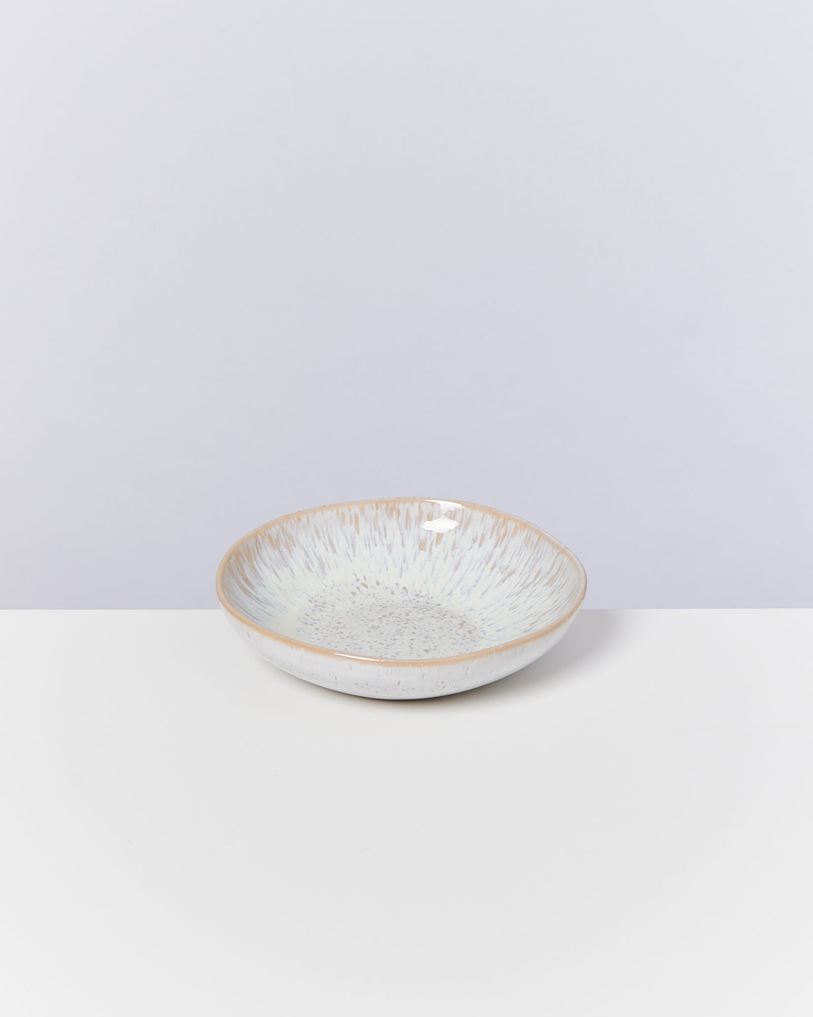 Keramikschüssel mit Muster auf weißem Hintergrund.