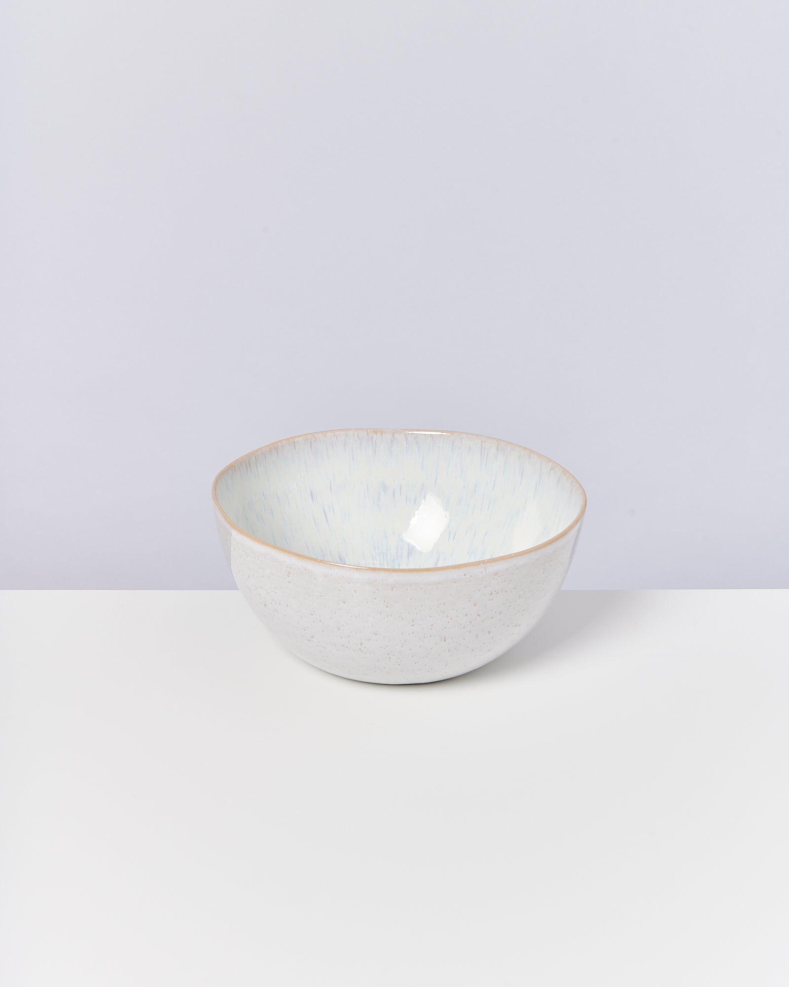 Keramikschale mit hellem, gesprenkeltem Muster auf weißem Hintergrund.