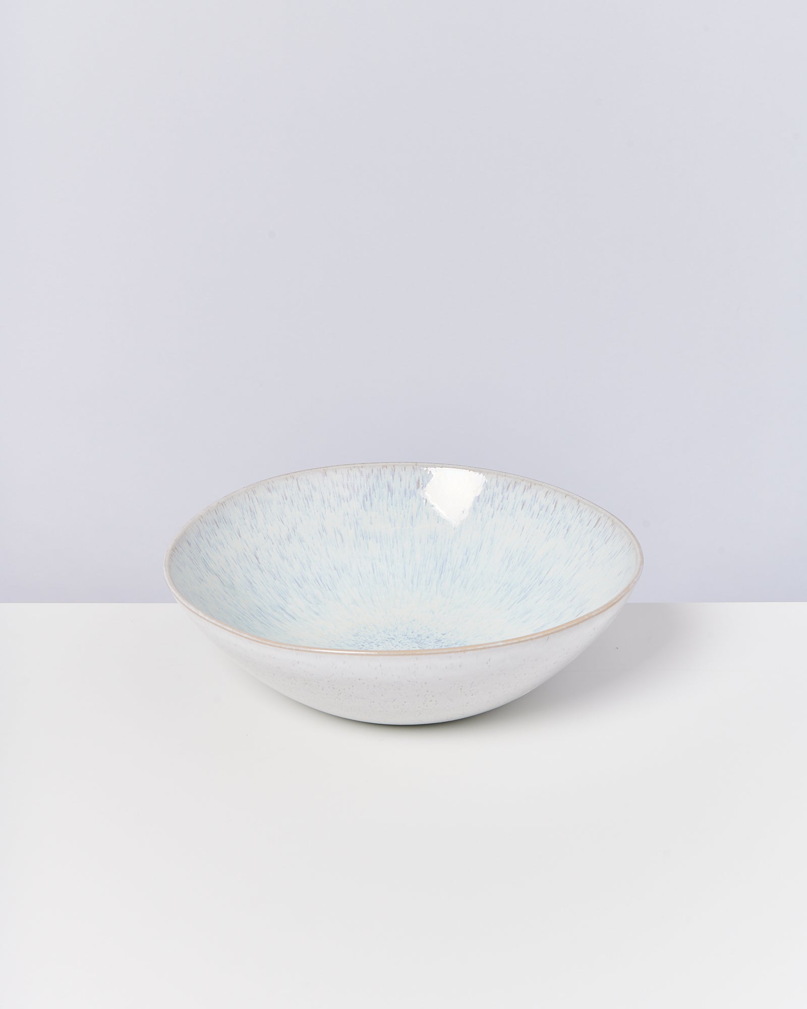 Weiße Schüssel mit hellblauem Innenmuster auf weißem Hintergrund.