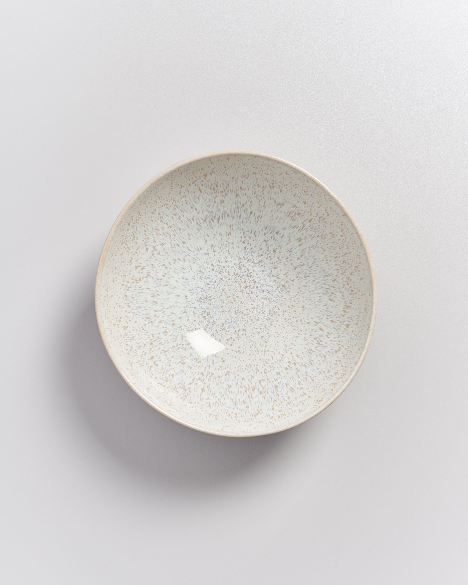 Keramikteller mit gesprenkeltem Muster auf weißem Hintergrund.