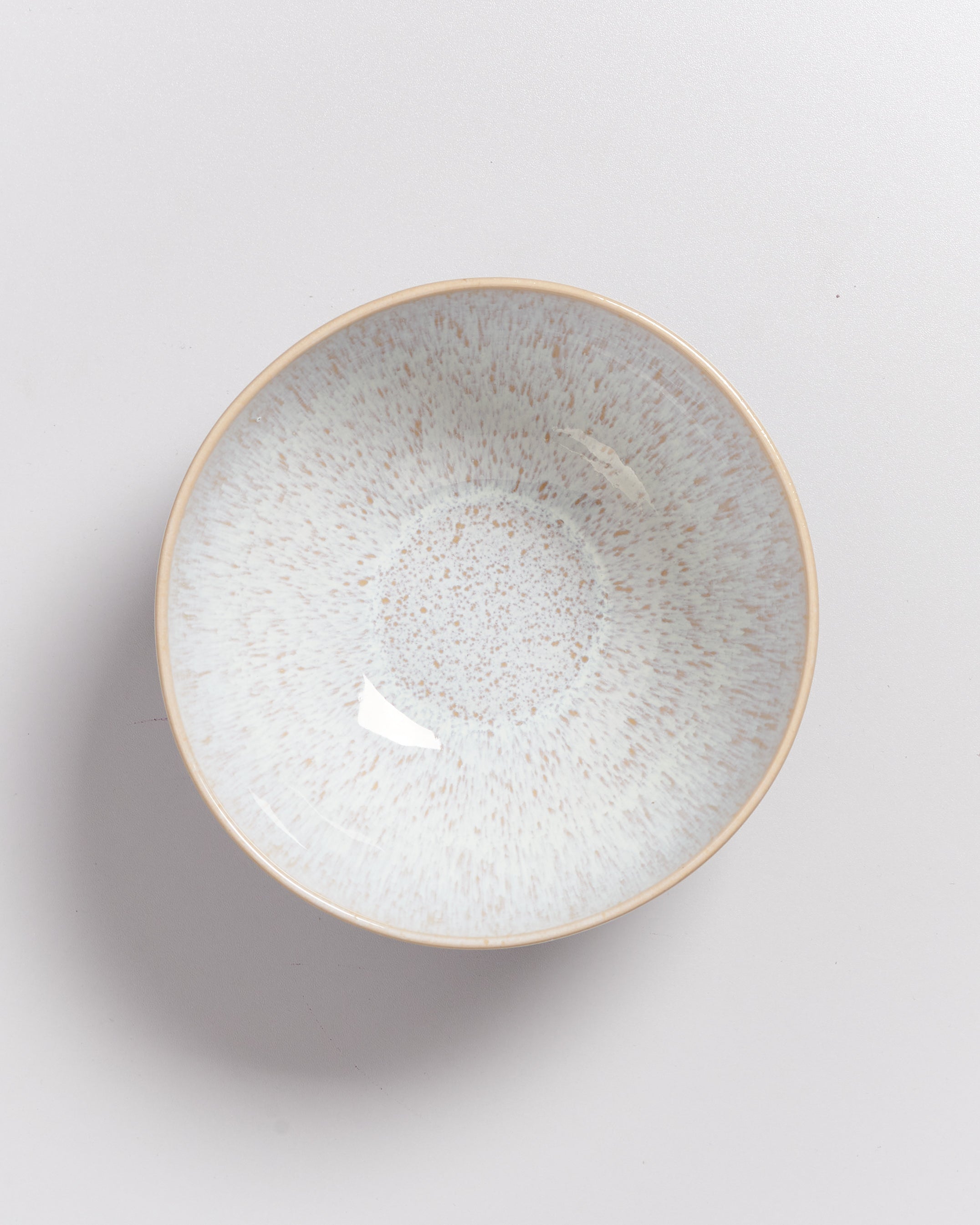 Keramikschale mit gesprenkeltem Muster auf hellem Hintergrund.