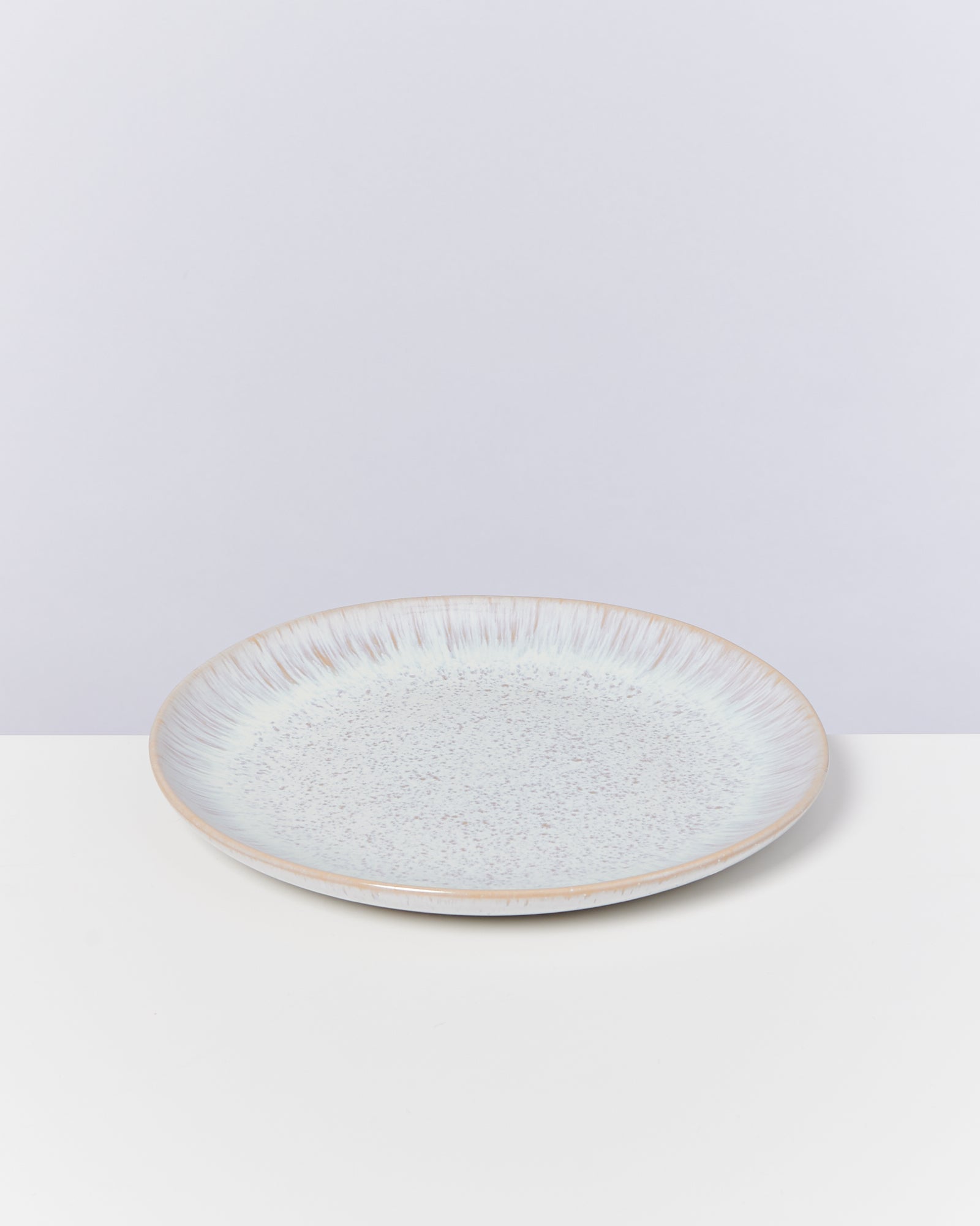 Keramikteller mit gesprenkeltem Design auf weißem Hintergrund.