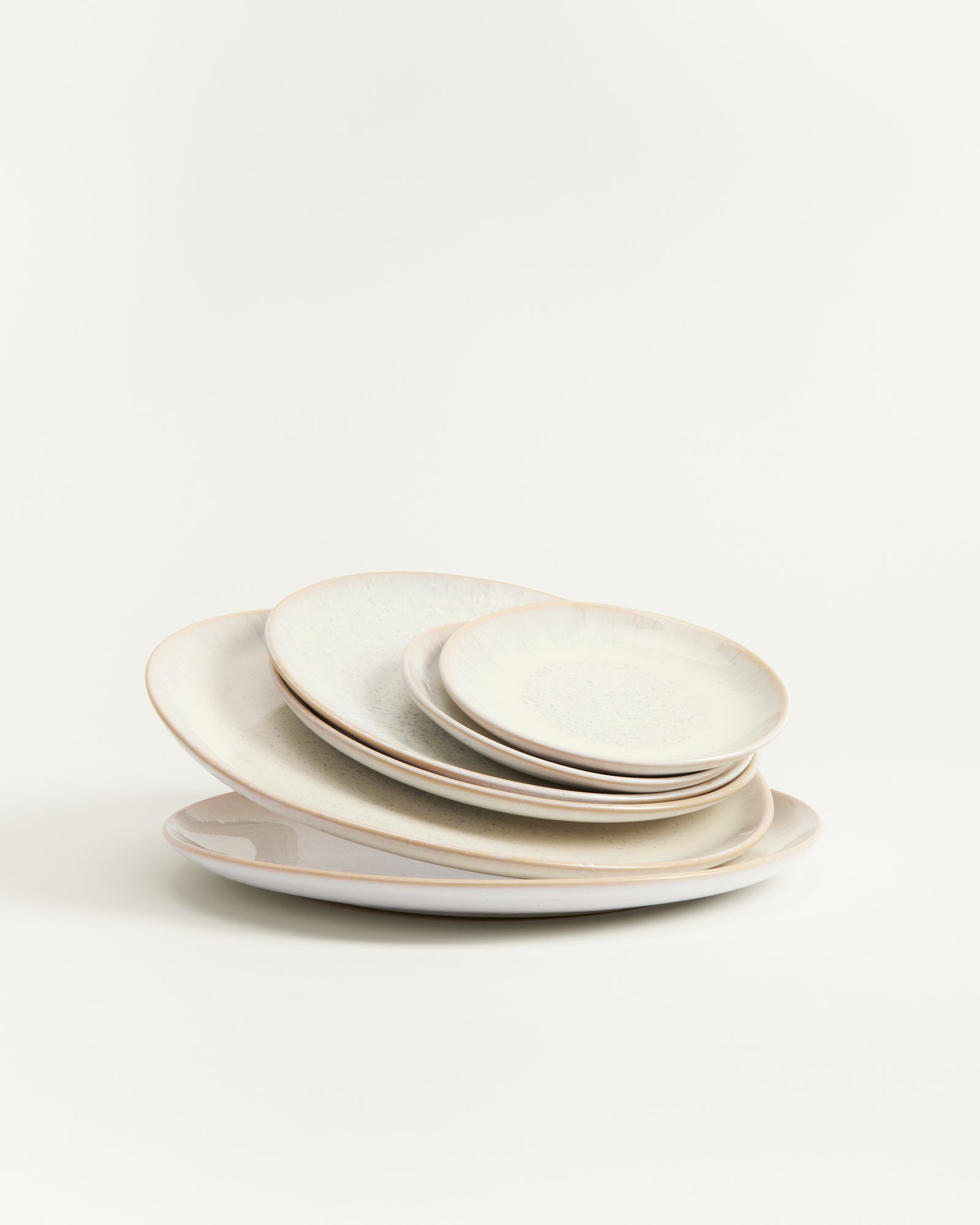 Ein Stapel weißer Teller in verschiedenen Größen auf einem hellen Hintergrund.