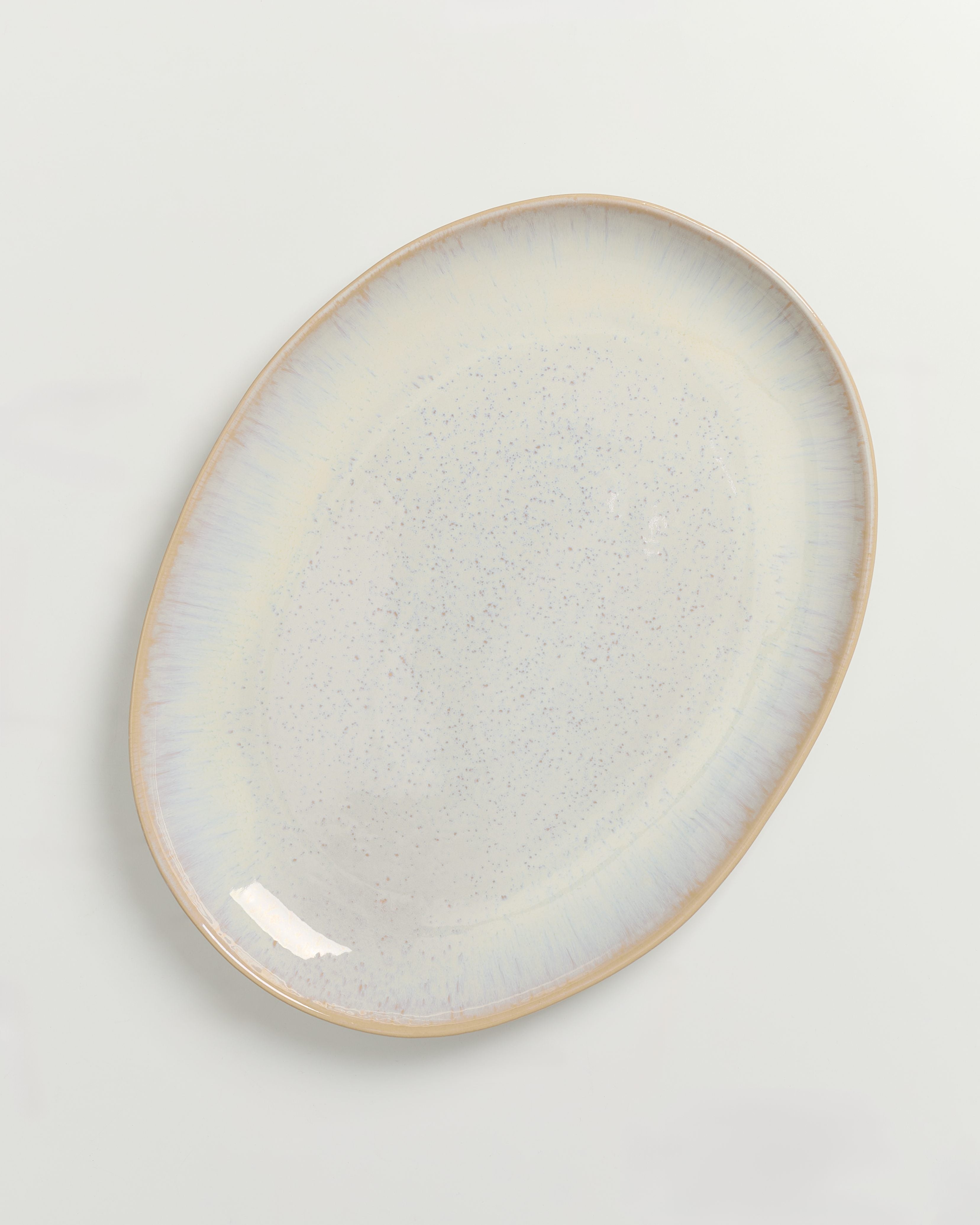 Ovaler Keramikteller in Pastellfarben mit subtiler Sprenkelung auf weißem Hintergrund.