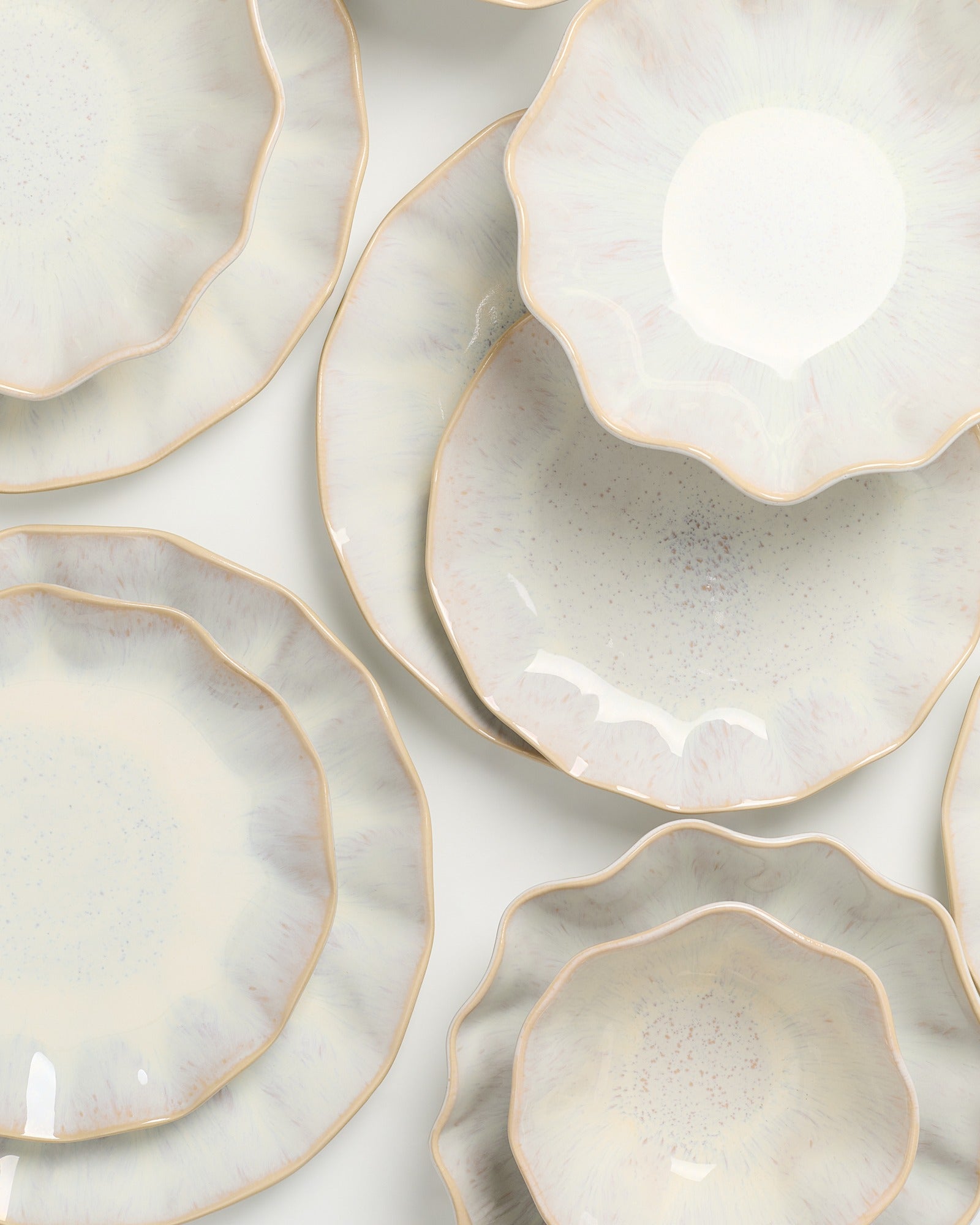 Verschiedene florale Teller mit gewellten Rändern und pastellfarbenem Muster auf weißem Hintergrund.