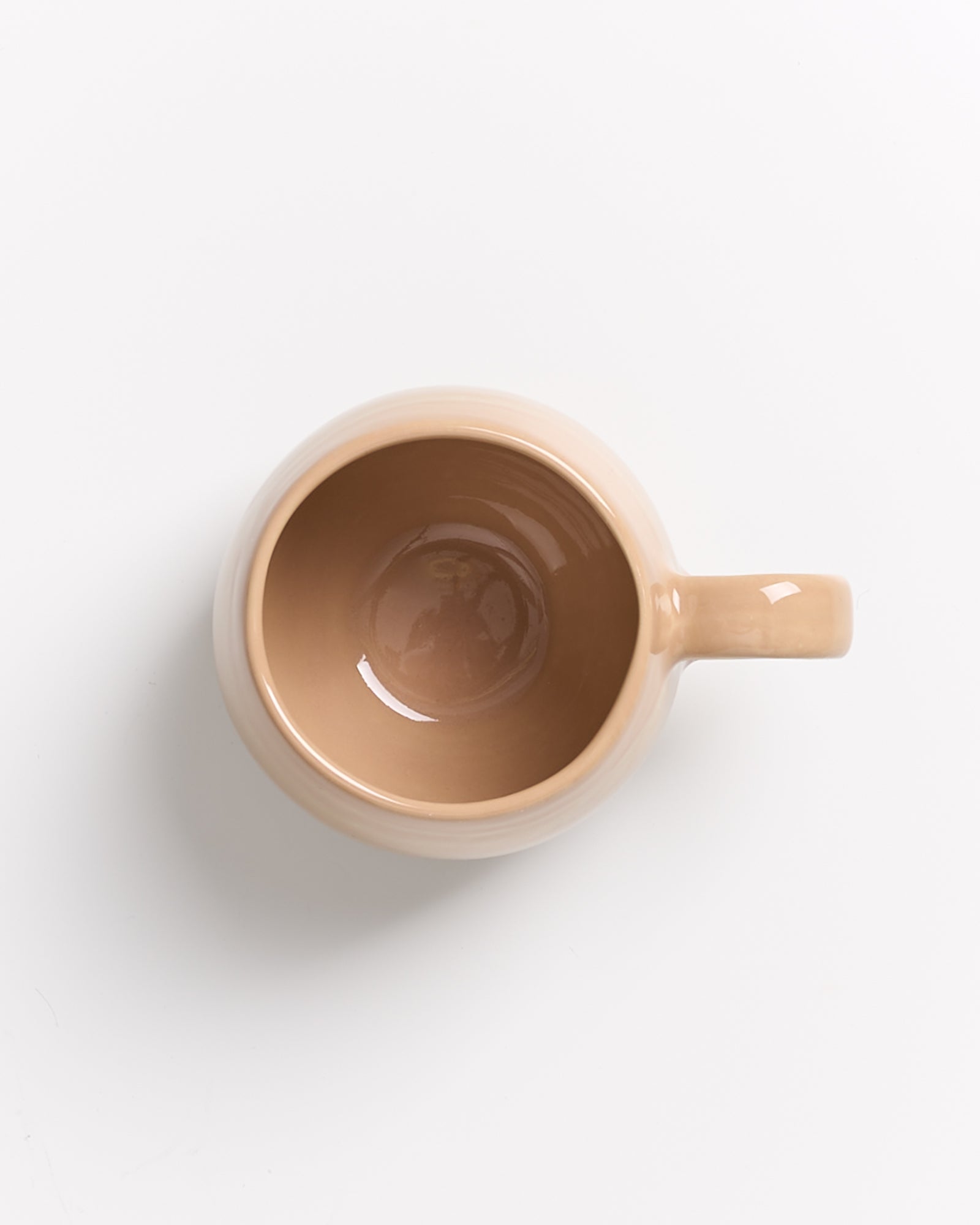 Beige Tasse von oben auf weißem Hintergrund.
