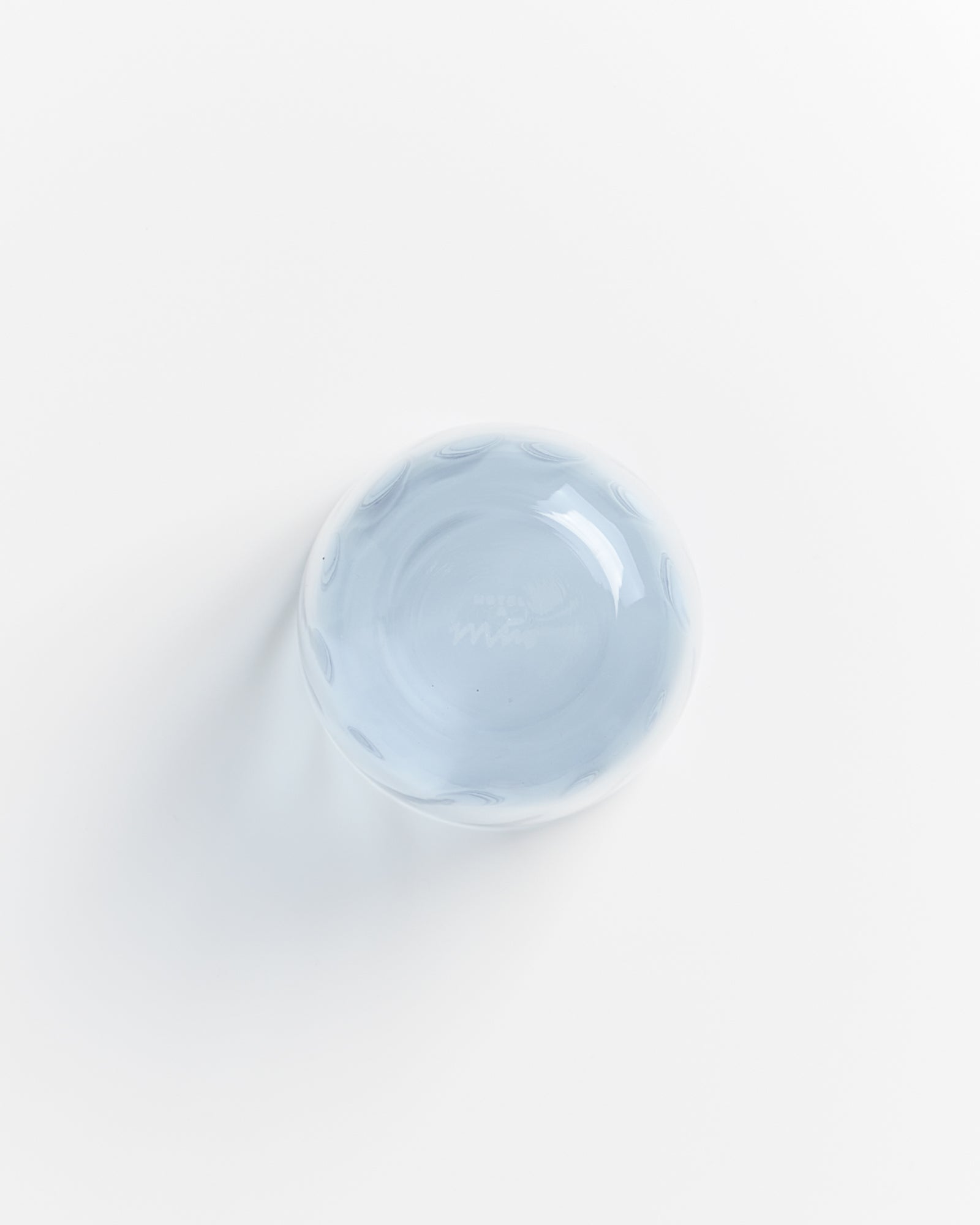 Blaue Glasschale von oben auf weißem Hintergrund fotografiert.